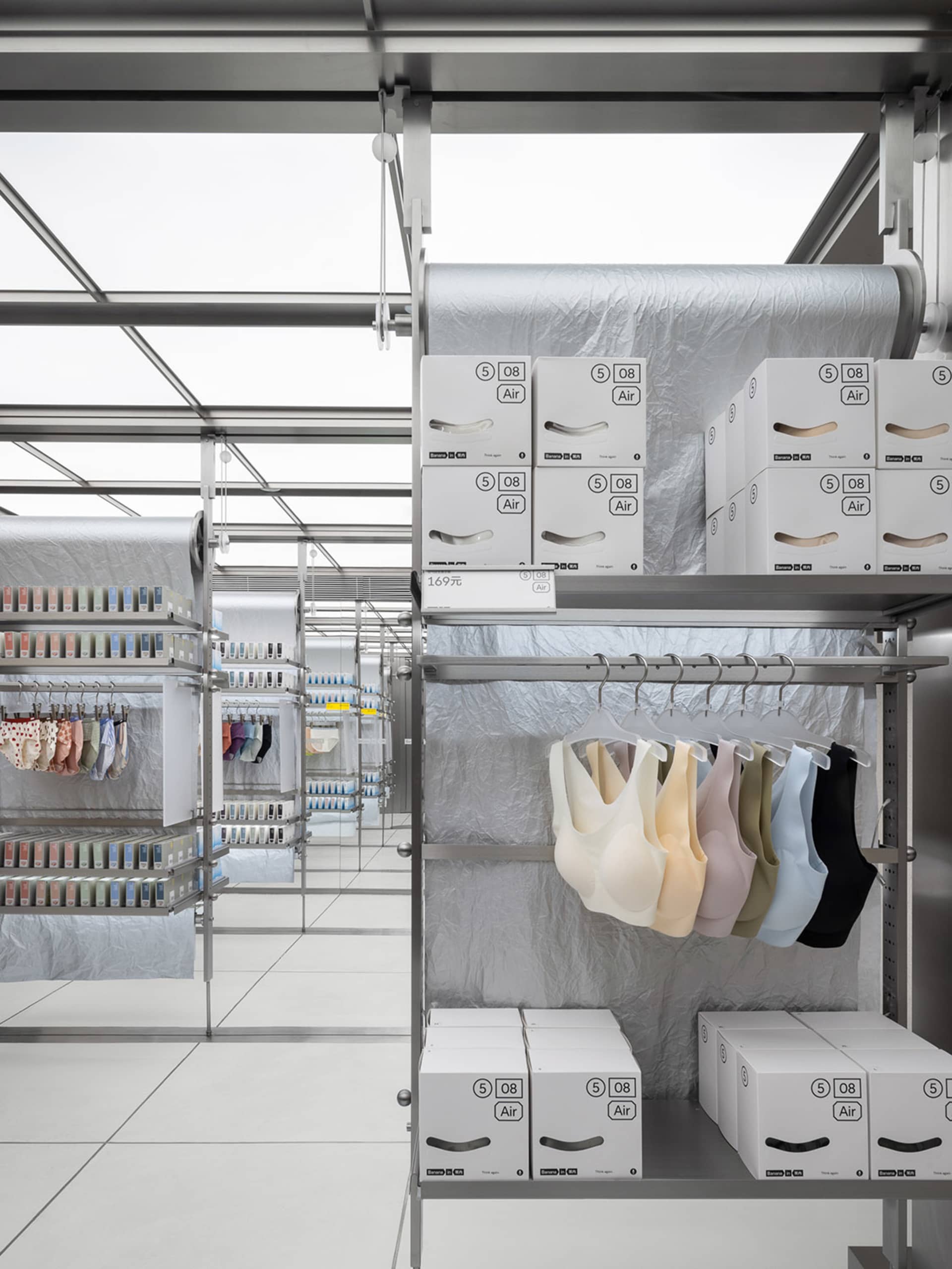 零售店內的金屬貨架展示服裝產品、產品紙箱與衣架。