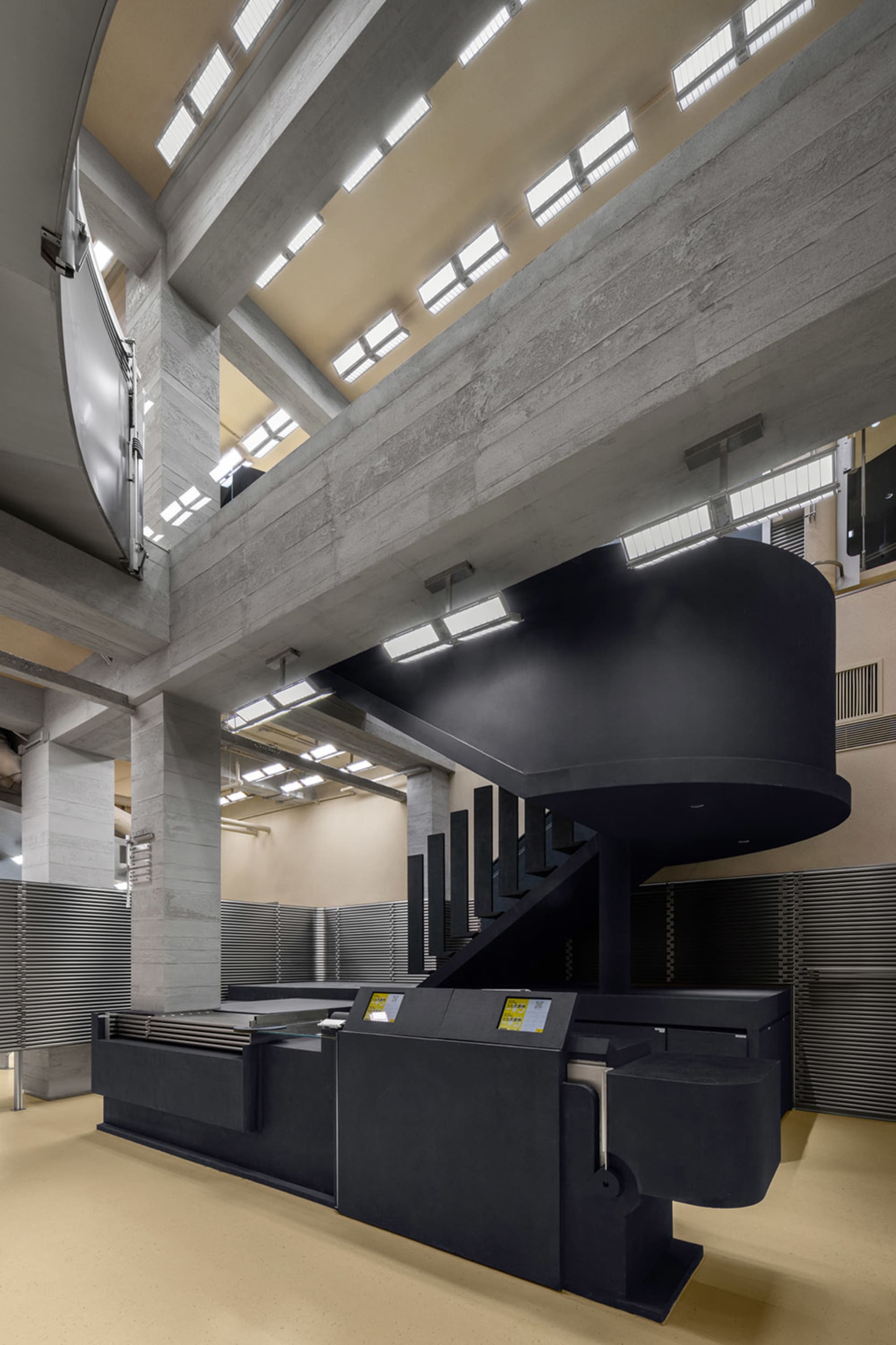 Office lobby with industrial design features, including concrete walls and structural beams.