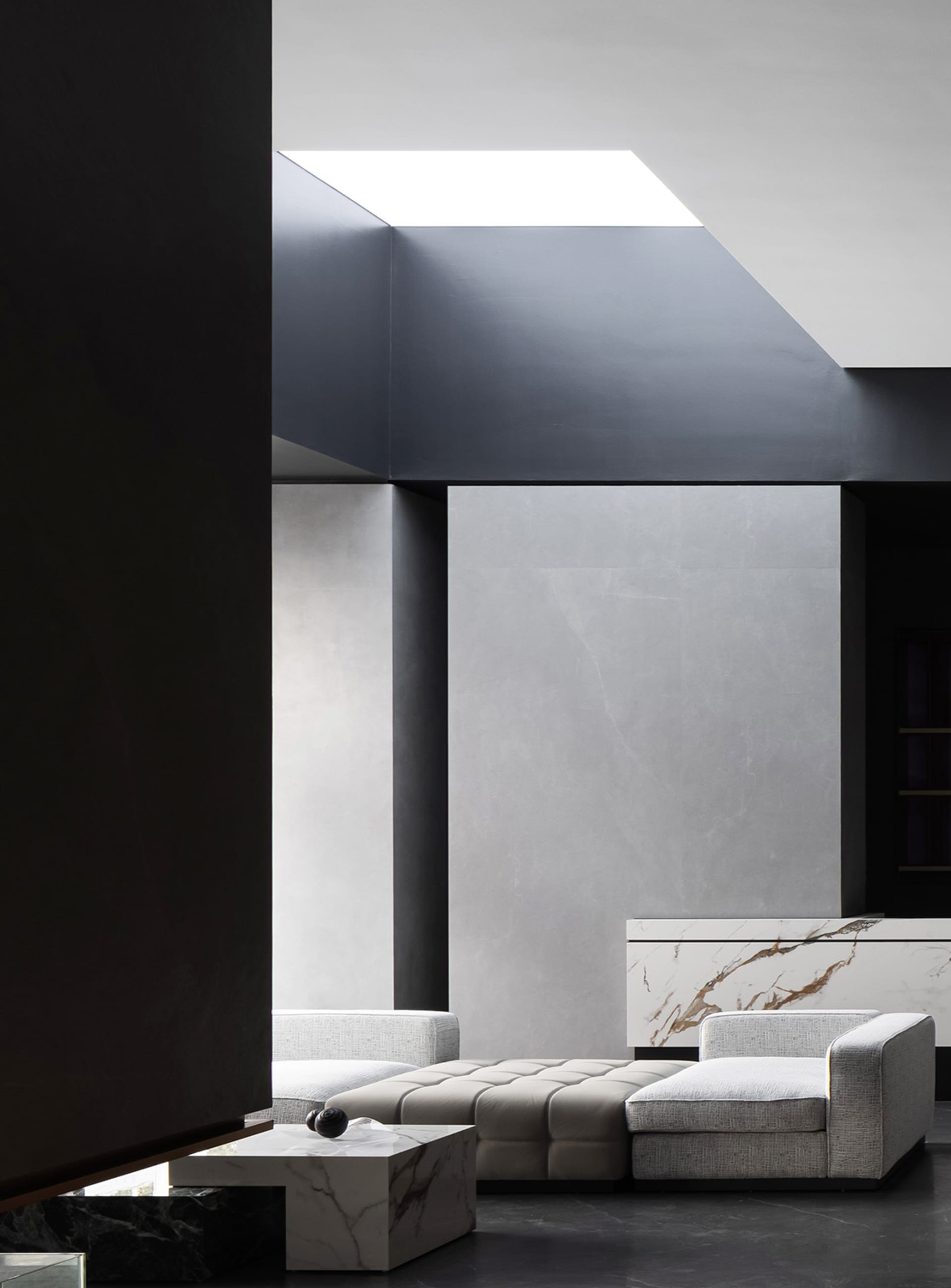 Contemporary living room featuring marble, concrete, and leather materials.