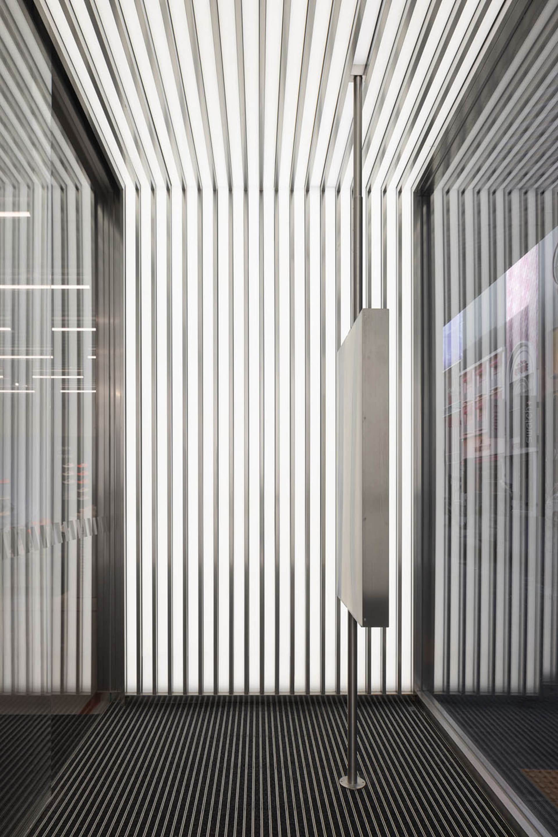 A modern interior space featuring metallic columns and vertical lines.