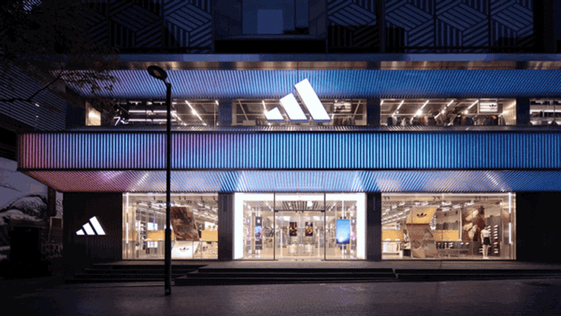 An Adidas retail storefront with large glass windows displaying merchandise.