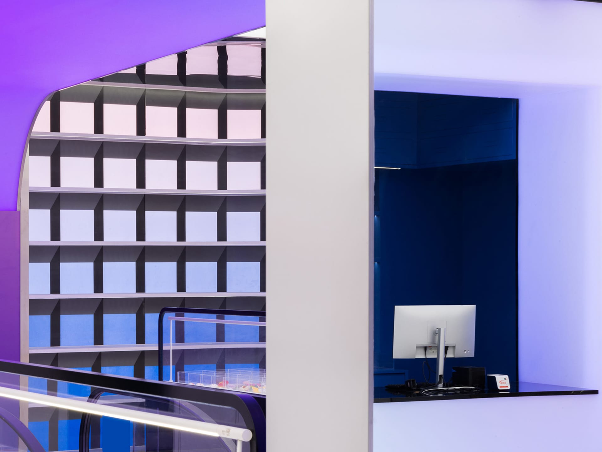 A modern office space with a glass counter and colorful cubes on the wall.