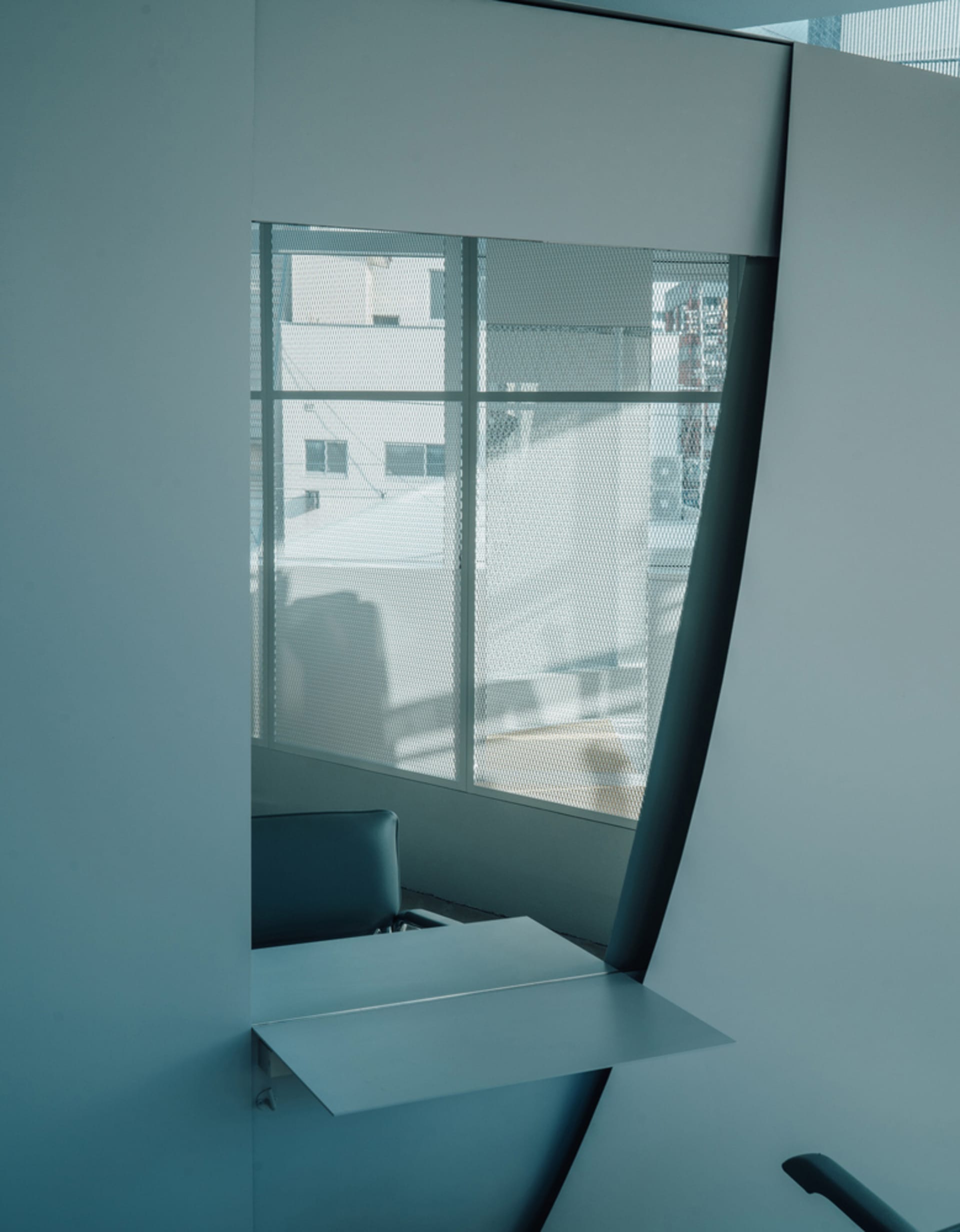 A minimalist chatroom interior with a modern window design, white walls, and metallic accents.