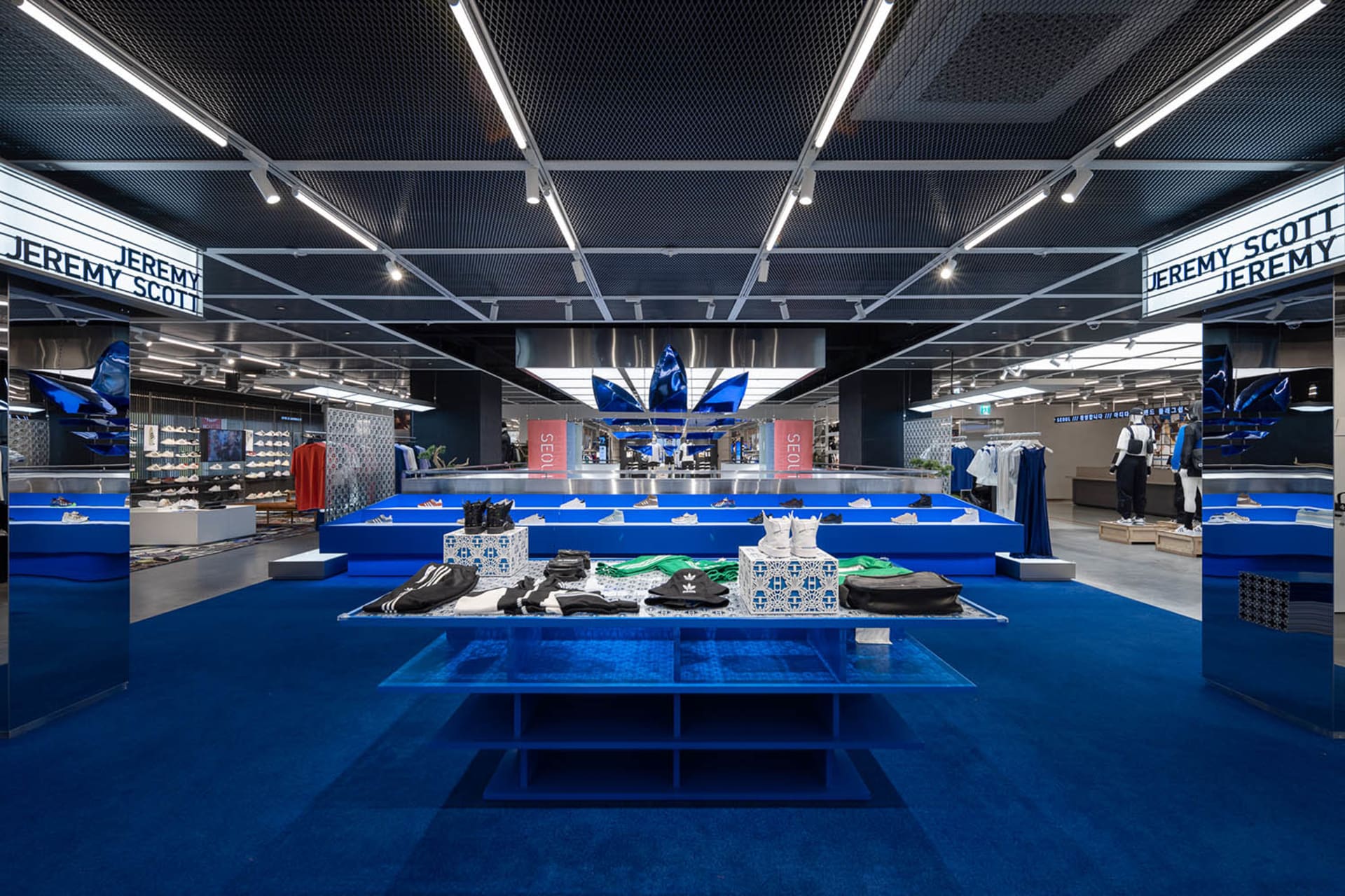 A modern retail space featuring steel, glass, and a blue carpet.