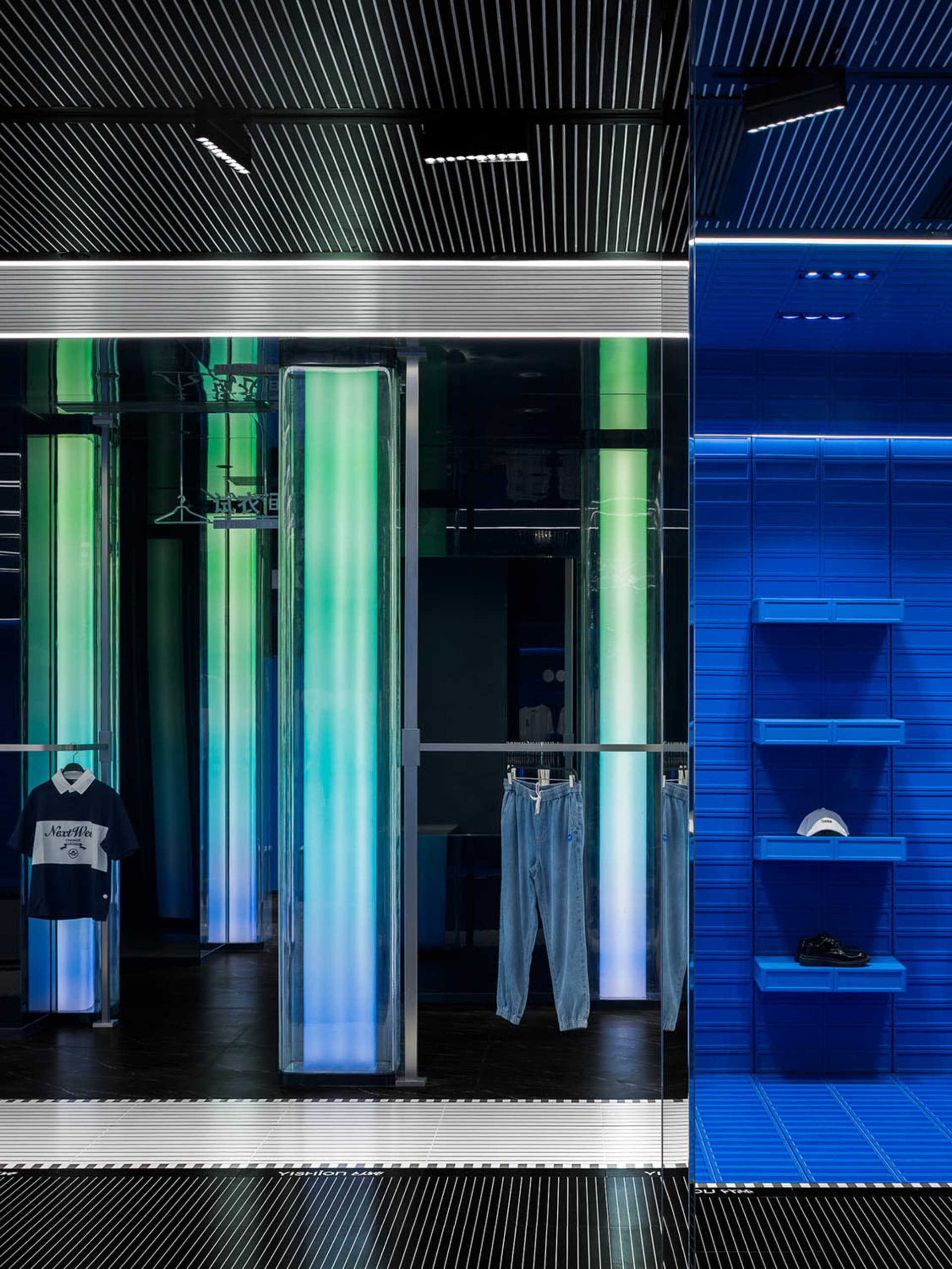 A modern retail outlet with glass doors, glass walls showcasing LED lights, and blue shelving units