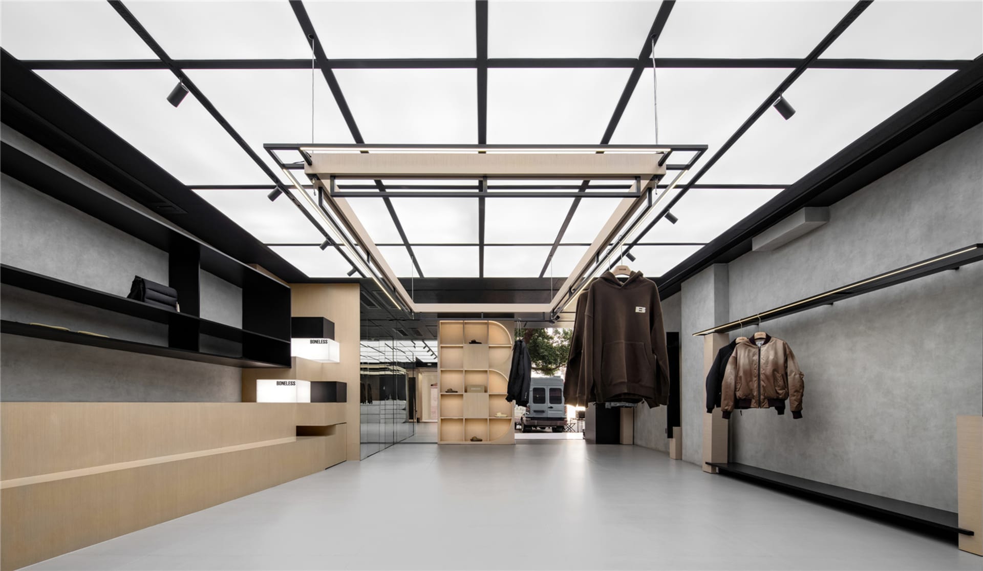 Modern retail clothing store showcasing minimalist design with concrete walls and metal accents
