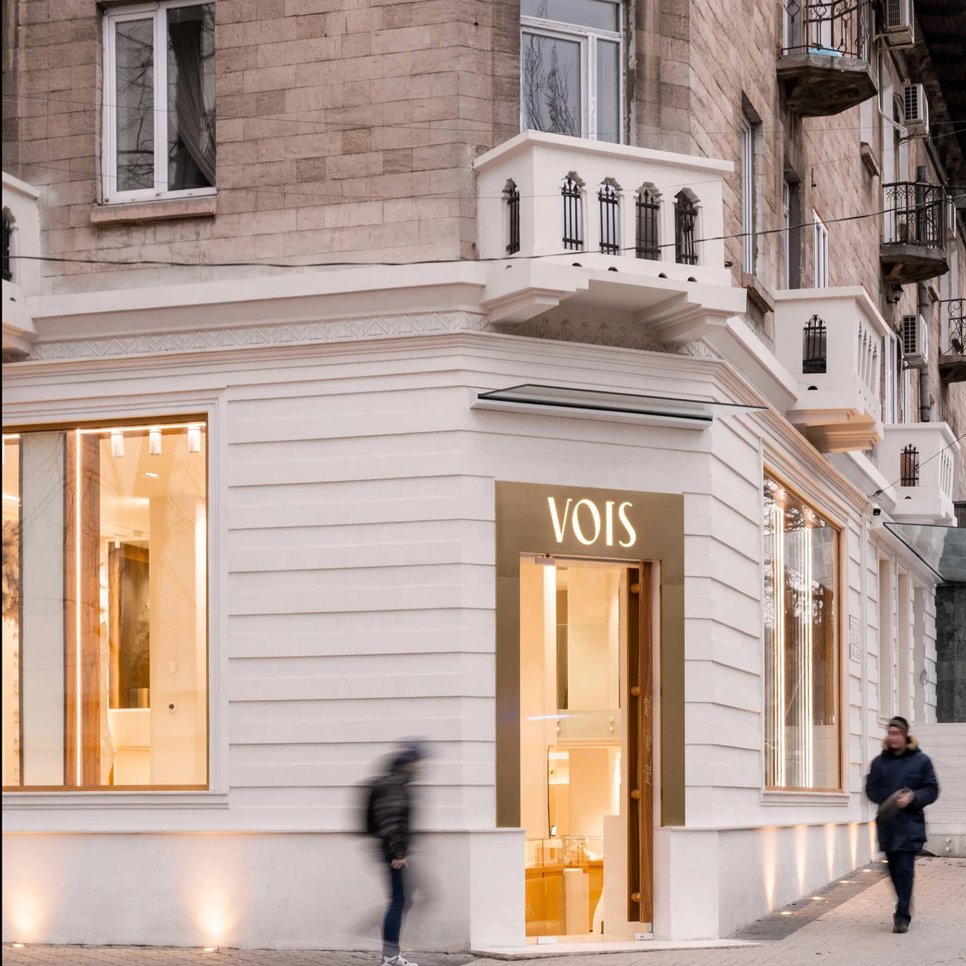 Modern retail storefront with large glass windows and illuminated signage.