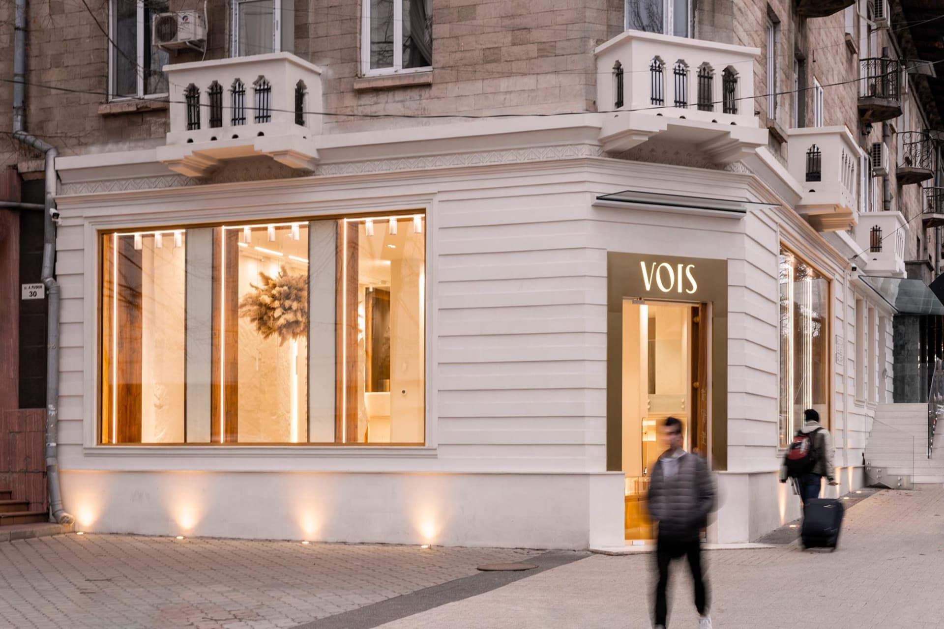 現代零售店面採用白石外觀，室內暖光照明。