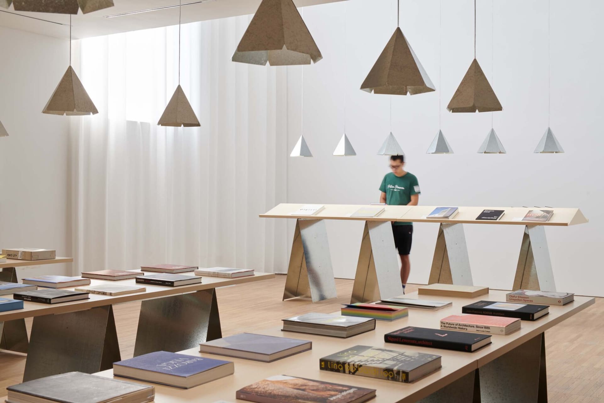Industrial bookstore interior with metal shelves and wooden tables featuring a variety of books.