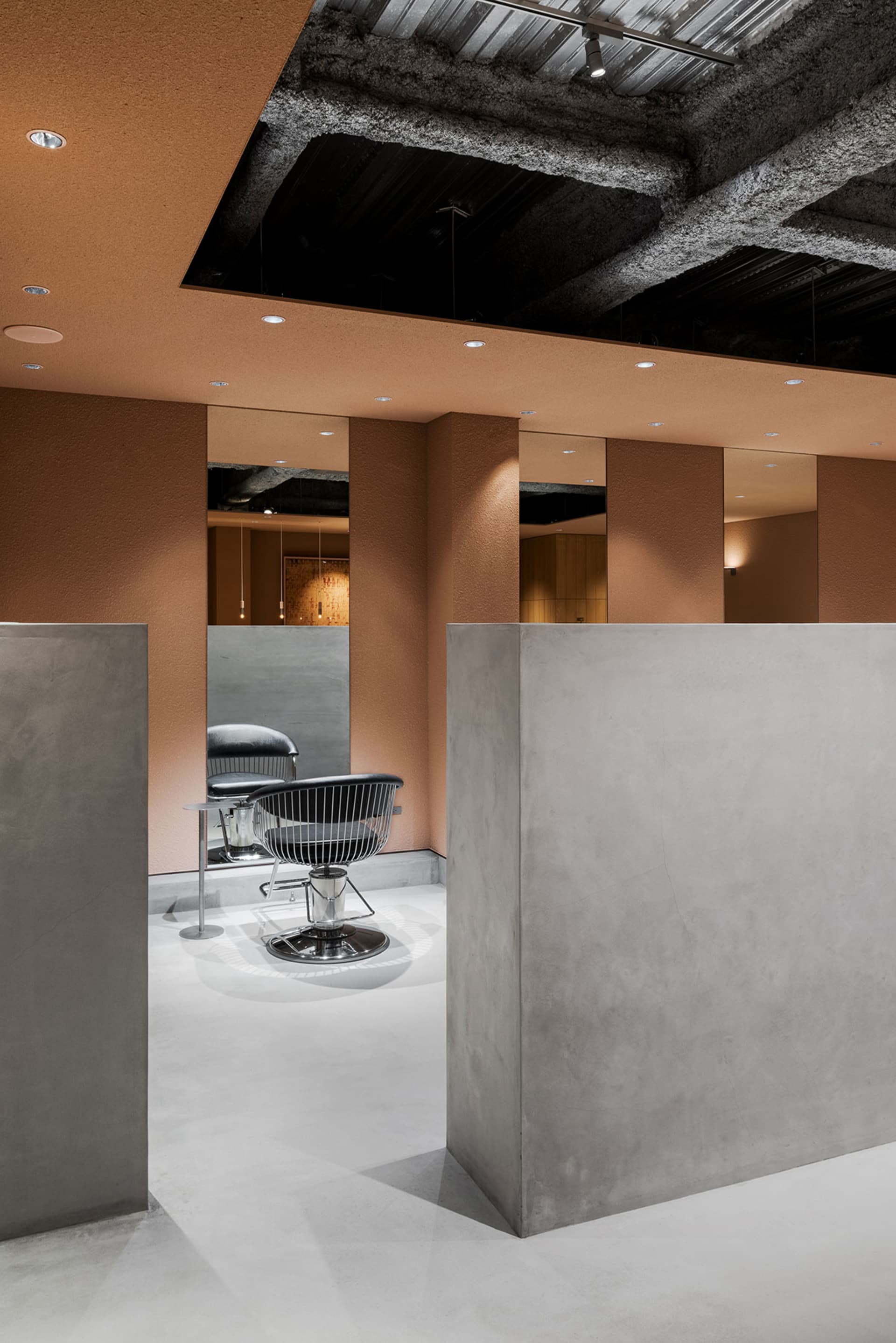 Industrial-style hair-saloon interior with concrete walls and ceiling