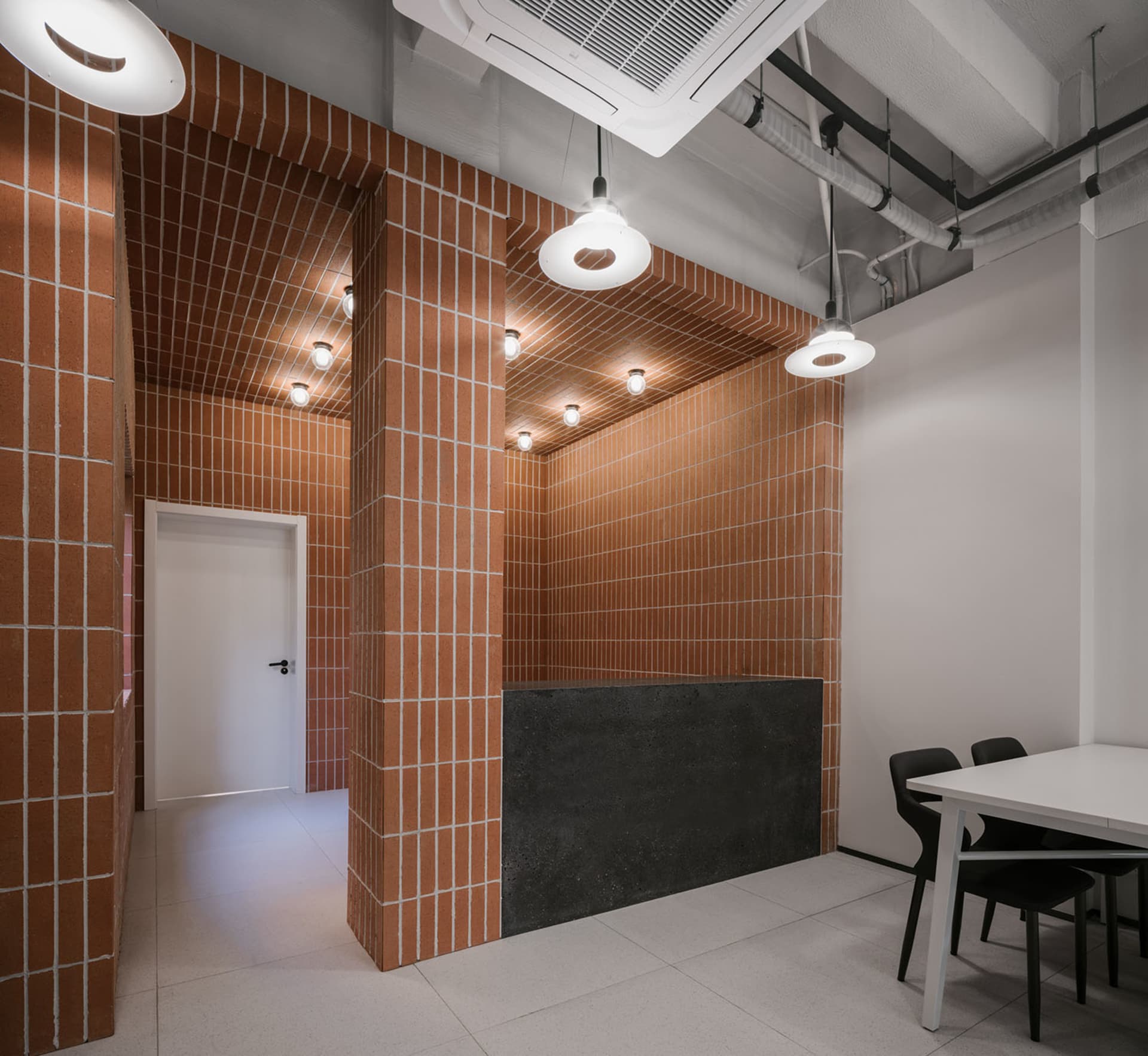 Industrial-style office entryway with a brick reception counter