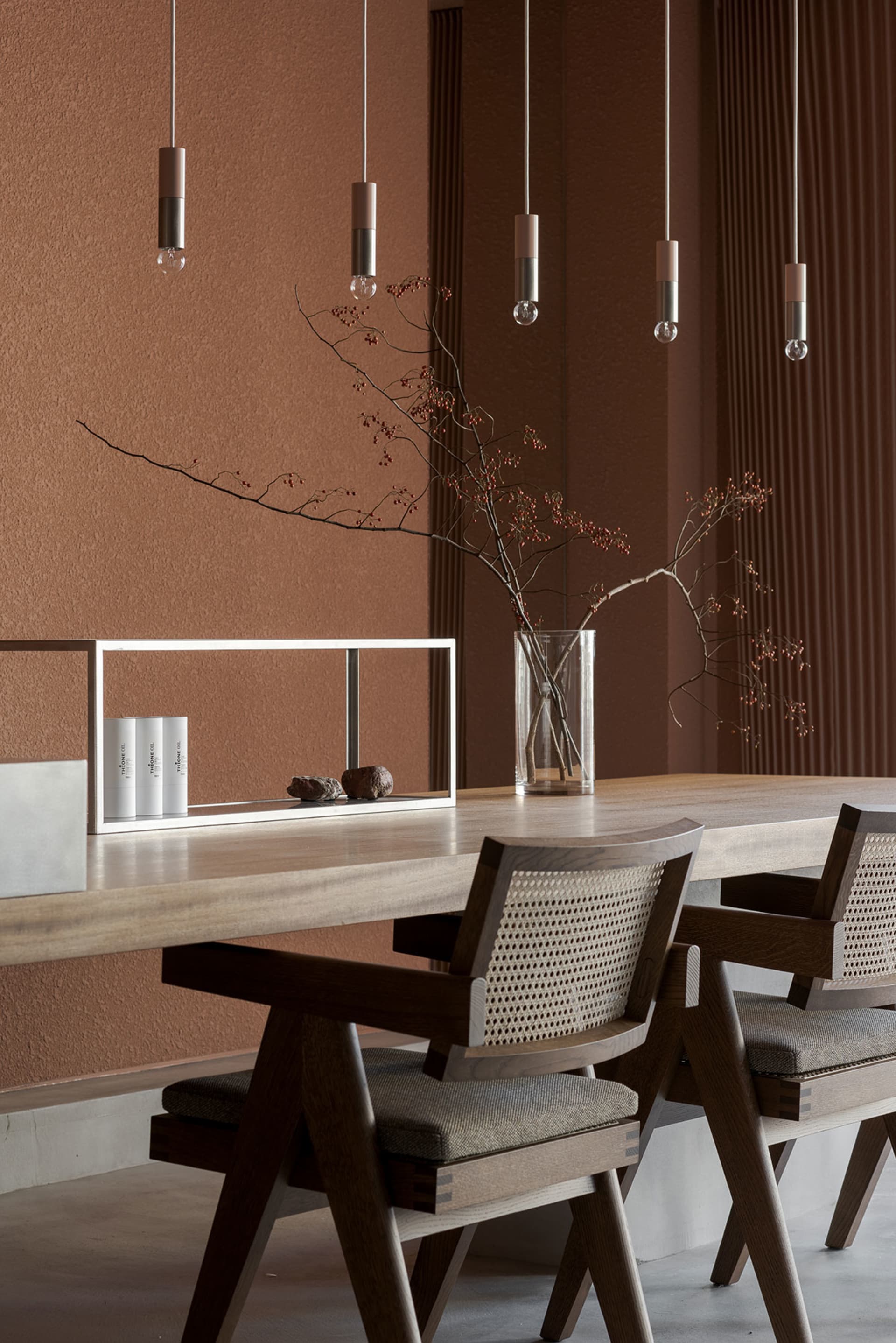 Modern dining room featuring a wooden table, chairs, and pendant lights.