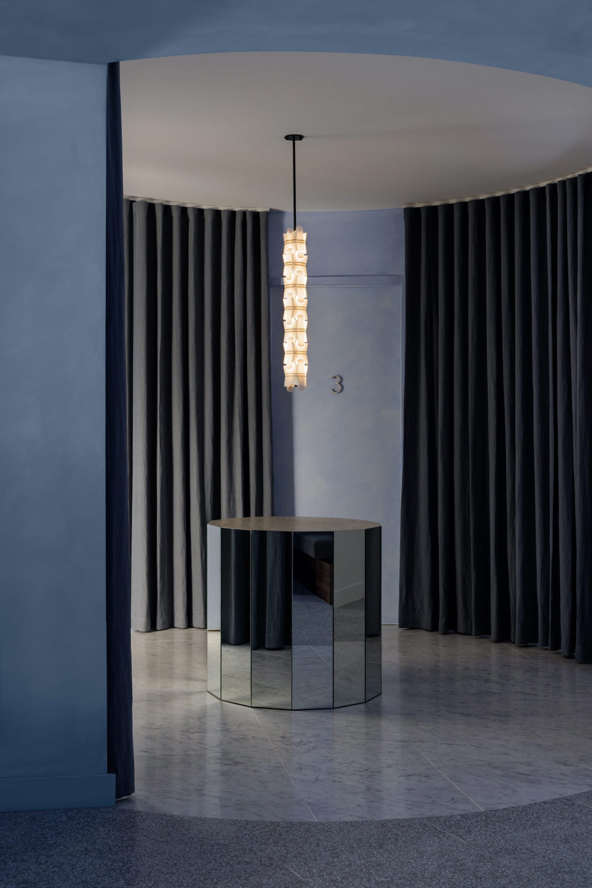 A minimalist lobby featuring a black mirrored panel with modern design elements.