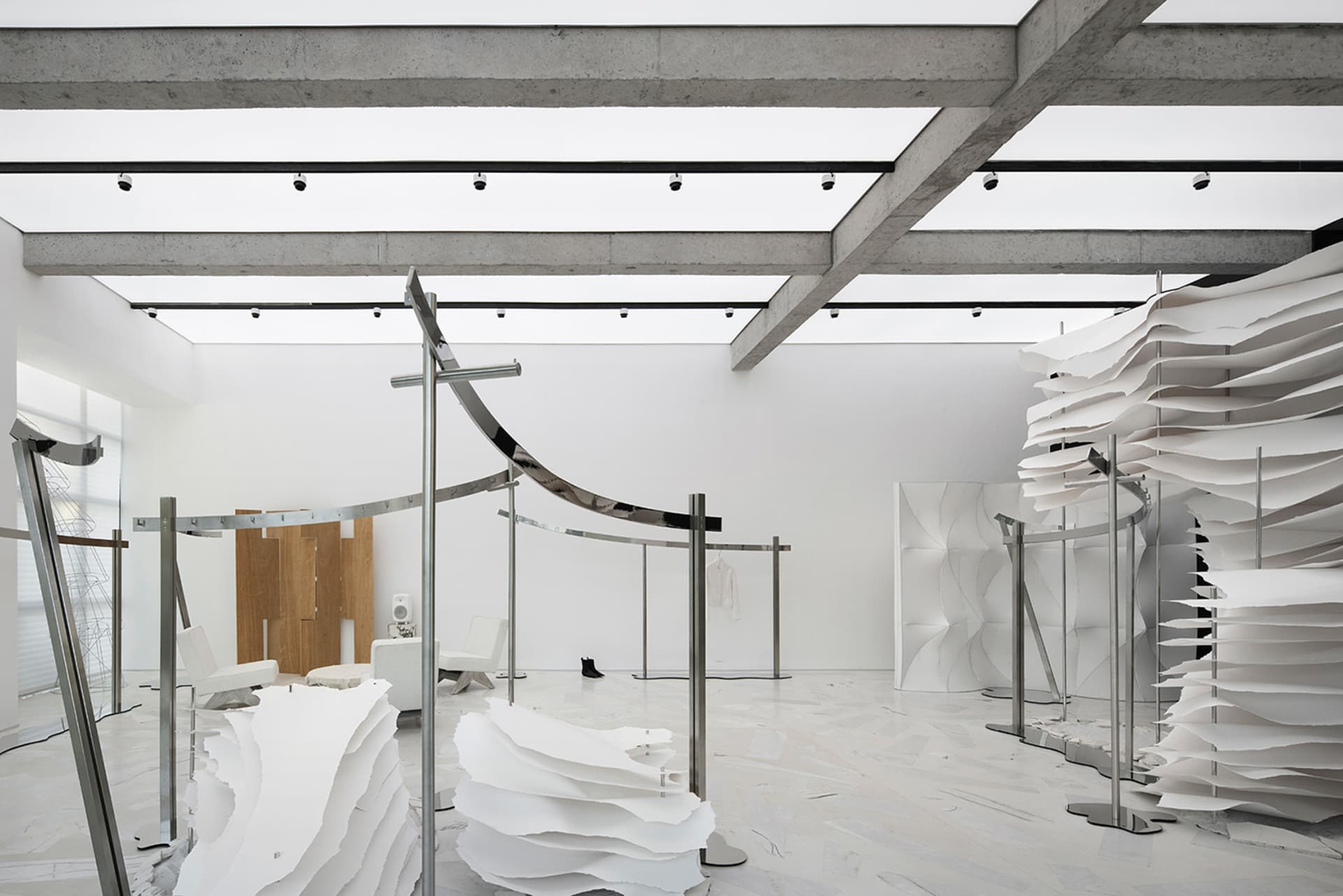 Minimalist exhibition space featuring paper and metal installations.