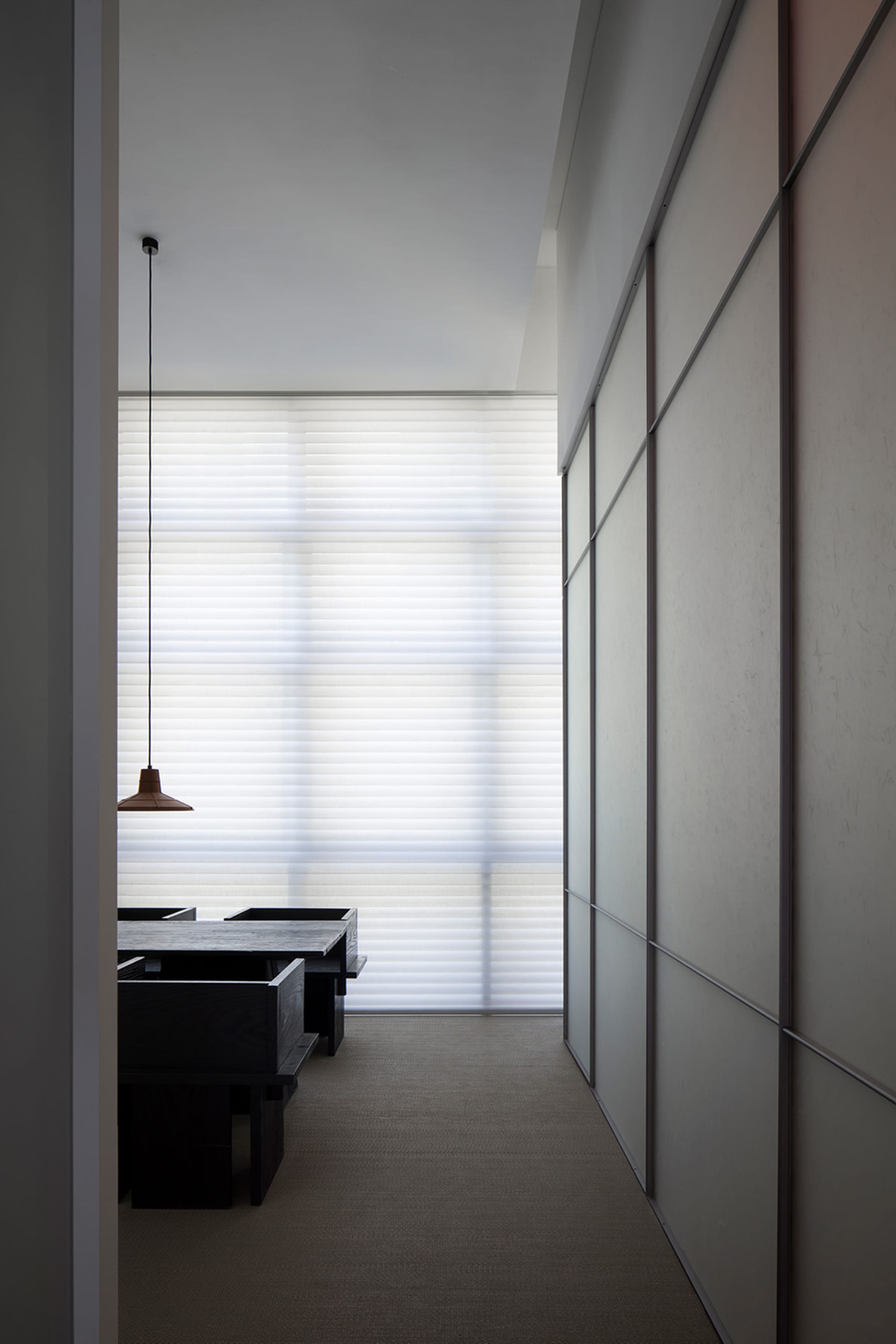 A minimalist office space with a white board and illuminated light.