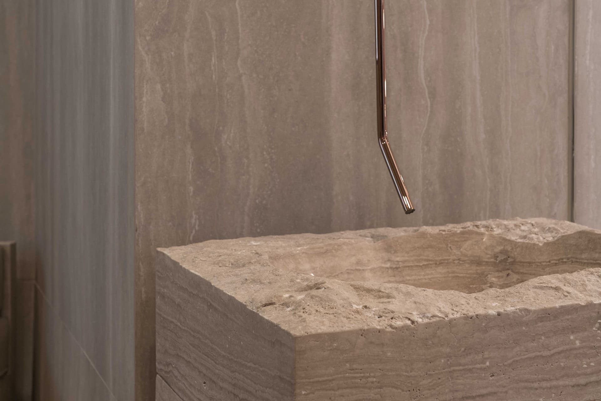 A modern interior with a stone sink, showcasing sleek and minimalist features.