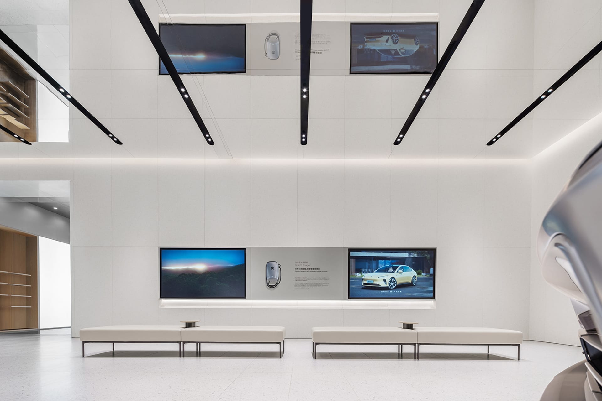 A spacious, minimalist white showroom featuring modern car designs and sleek interior designs.