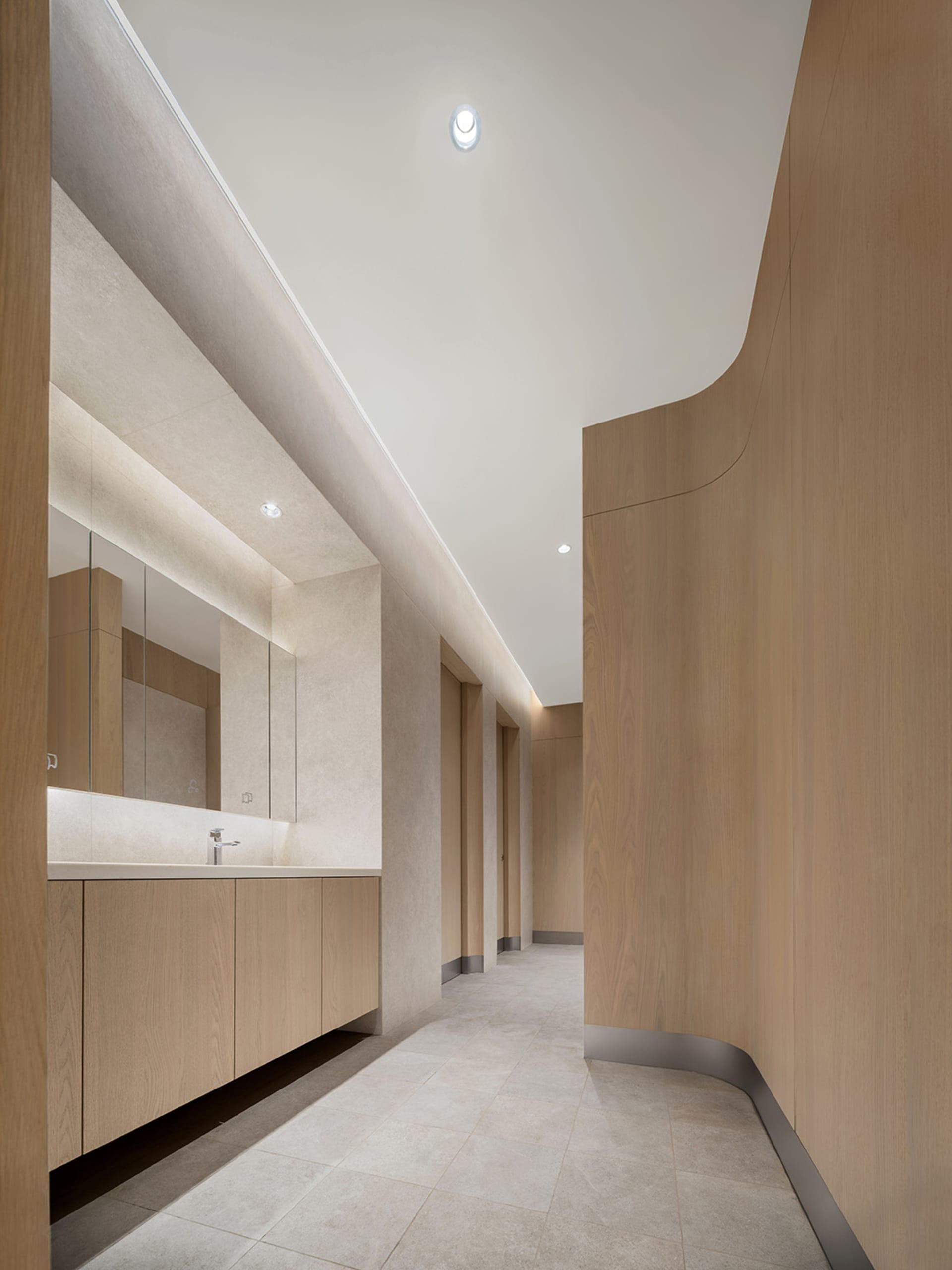 Modern public restroom featuring concrete and wooden walls and flooring.