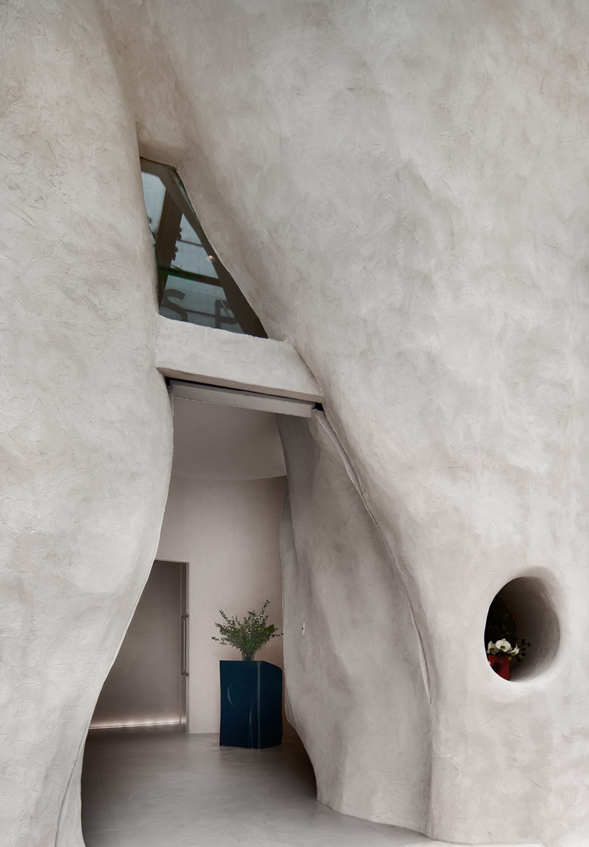 Modern interior design featuring concrete walls and a sculptural staircase
