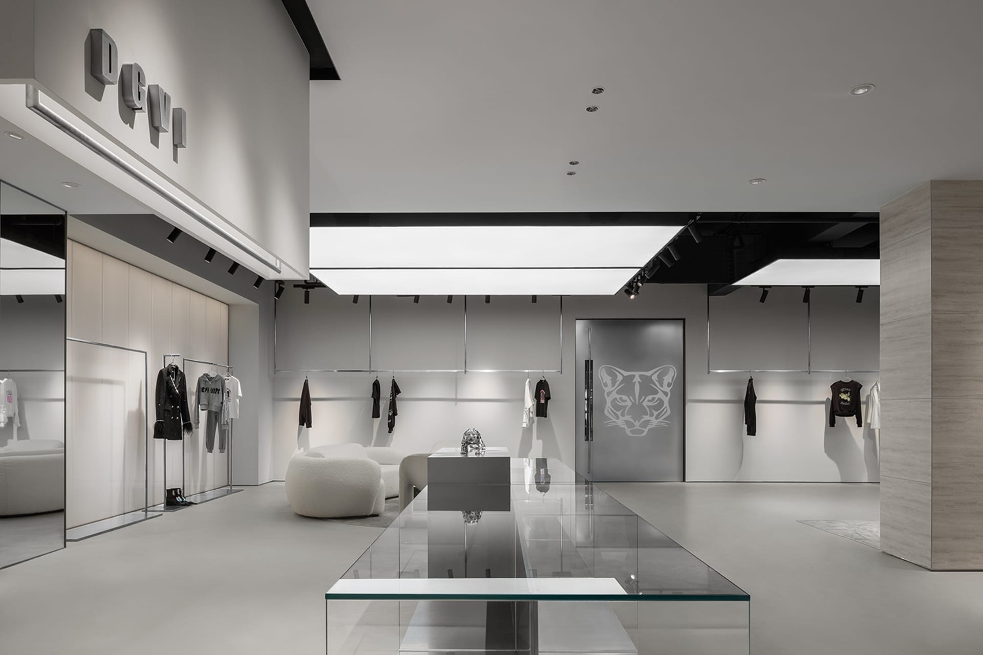 Modern minimalist retail storefront with white walls, floors, and furniture, featuring neutral tones and sleek design element