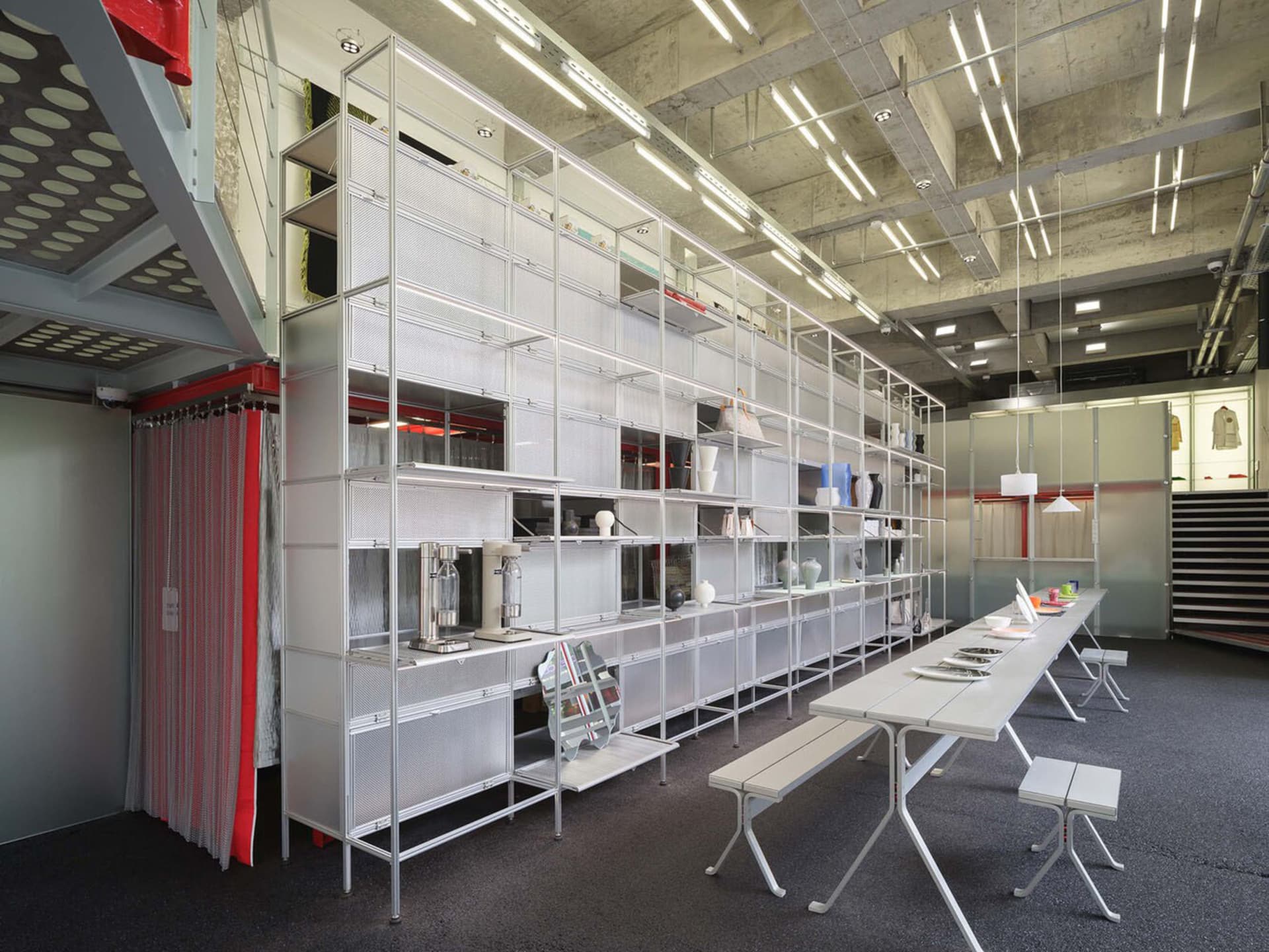 A spacious showroom featuring industrial-style furniture made of metal and glass.