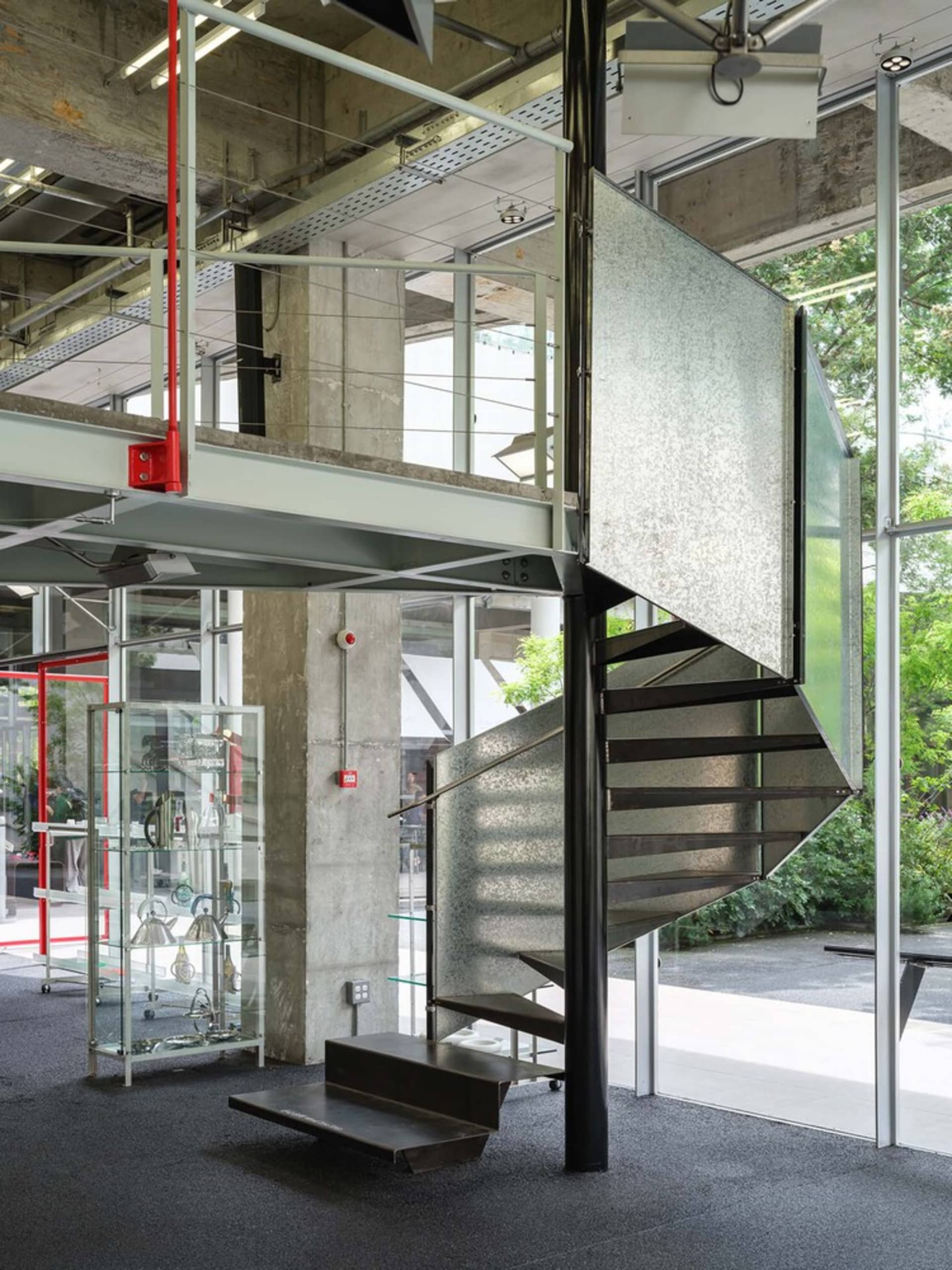 A modern business office featuring a metal and glass spiral staircase.