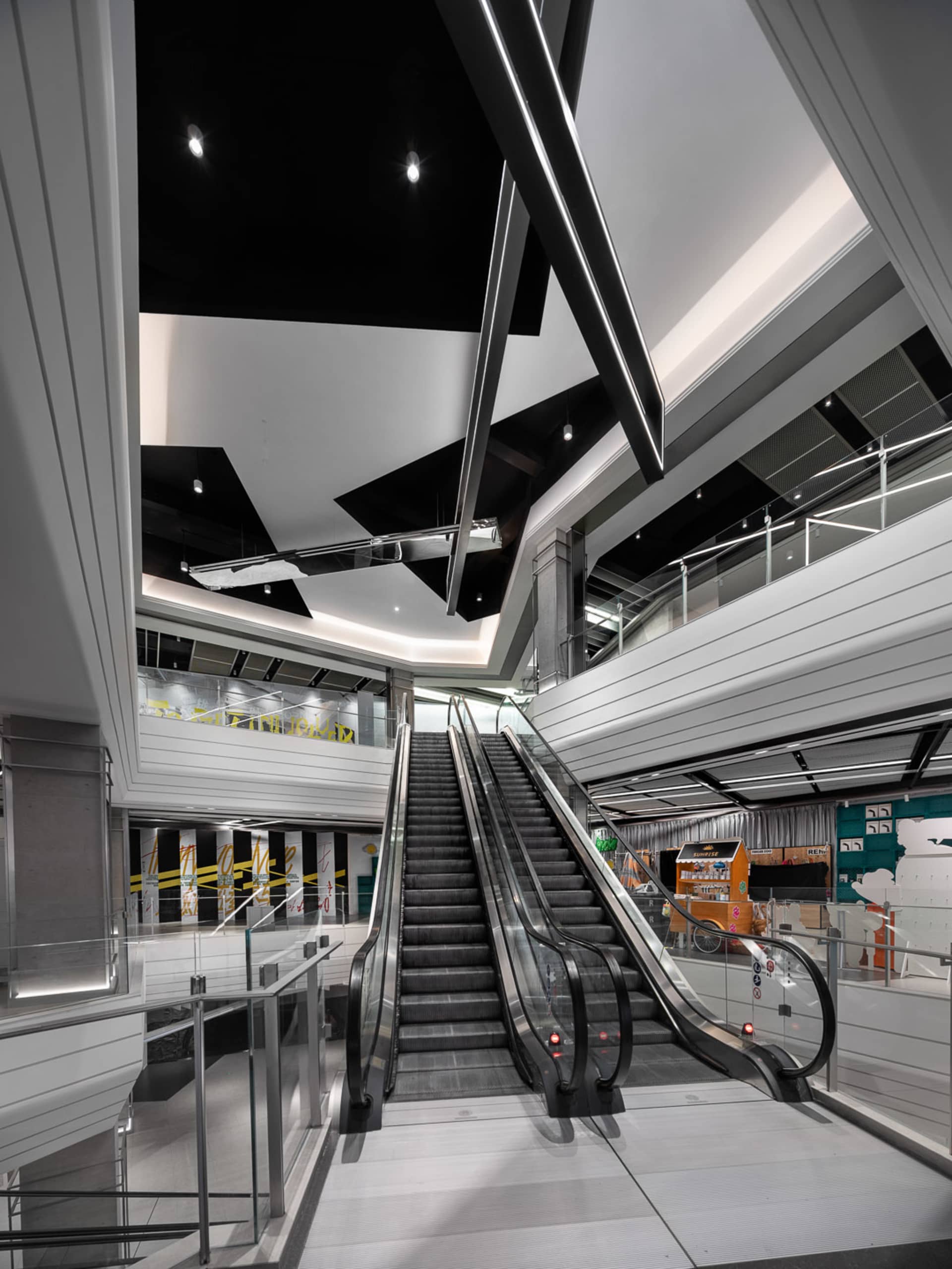 Modern interior design featuring a sleek, metallic escalator and contemporary architectural elements.