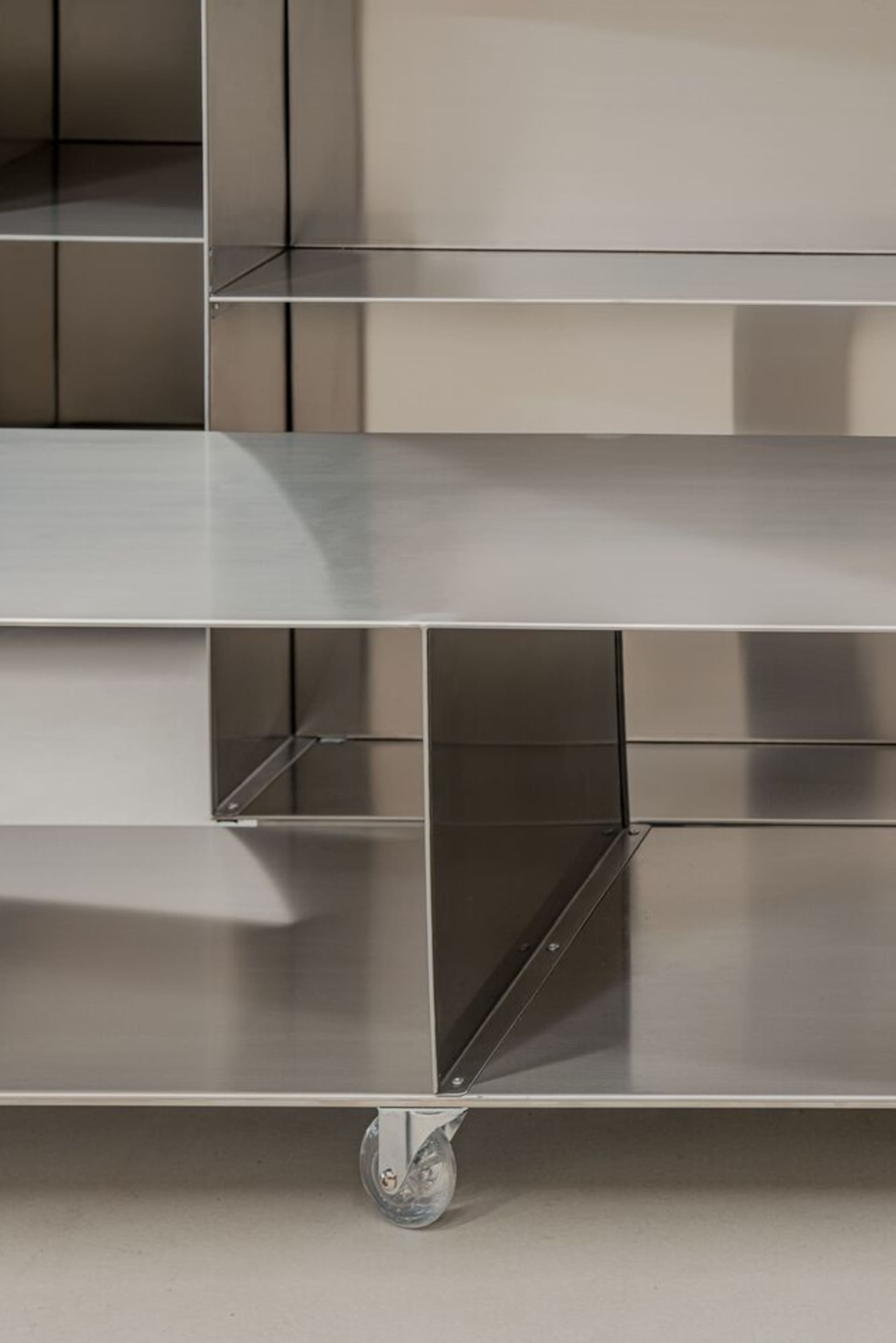 Clean-lined, metal shelving unit with wheels.