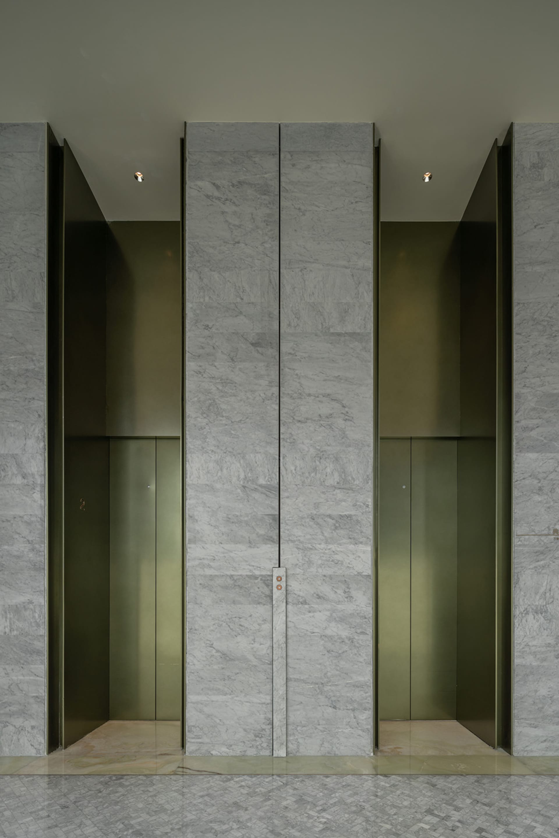 A modern lobby featuring glass elevator doors.