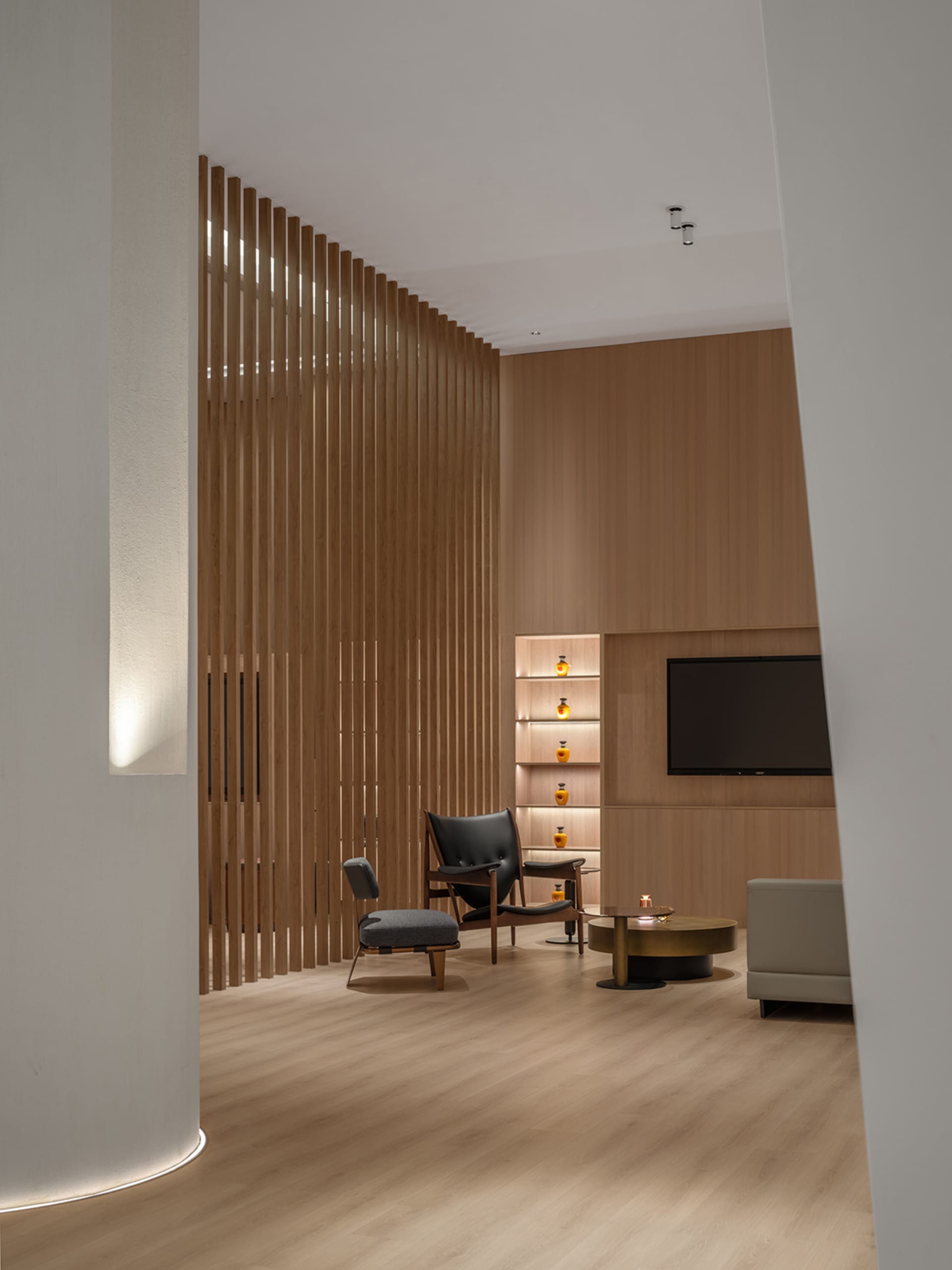 A modern interior design featuring a library room with wooden panels and shelves.