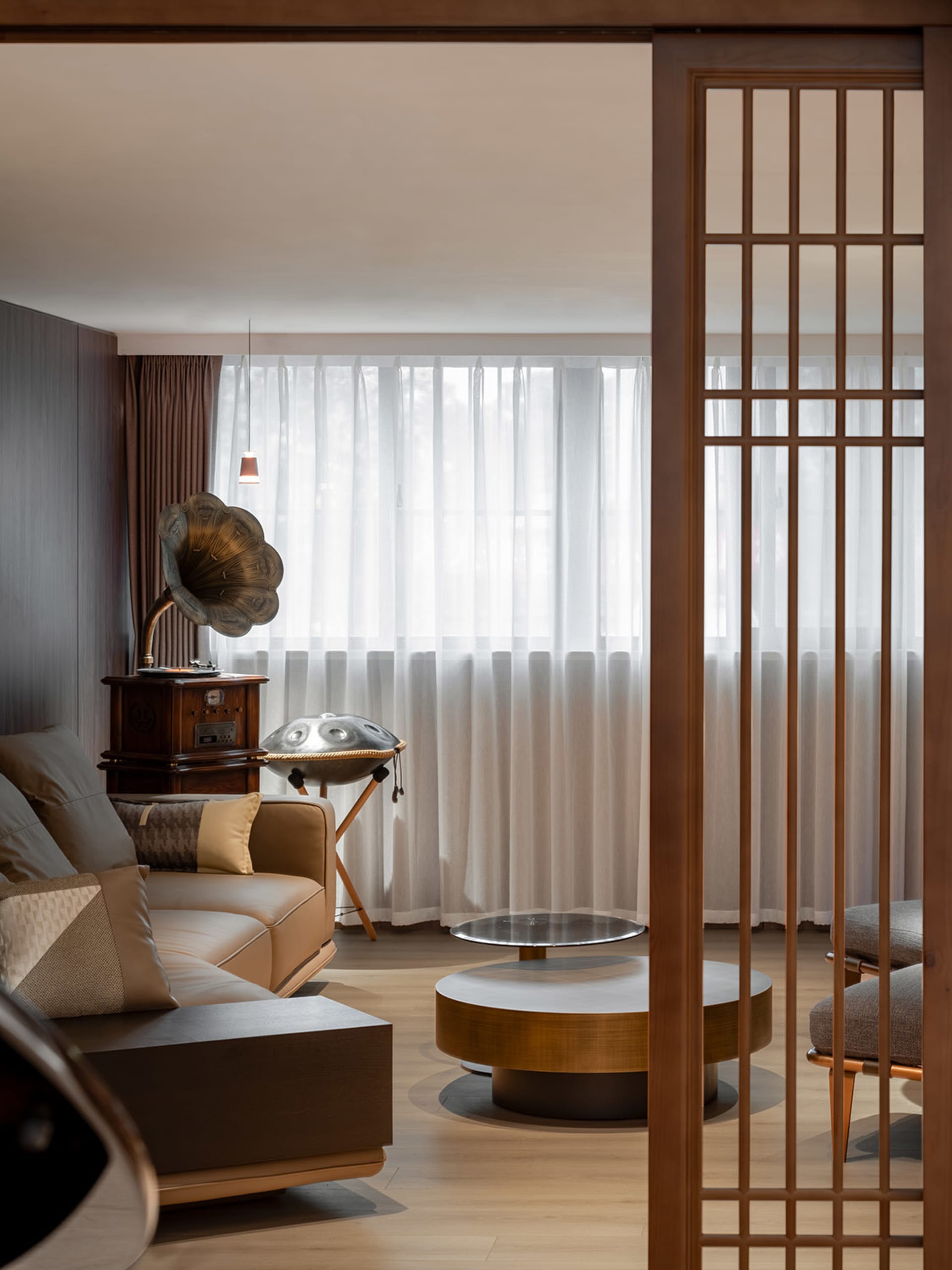 A modern living room featuring wood, leather, and glass materials