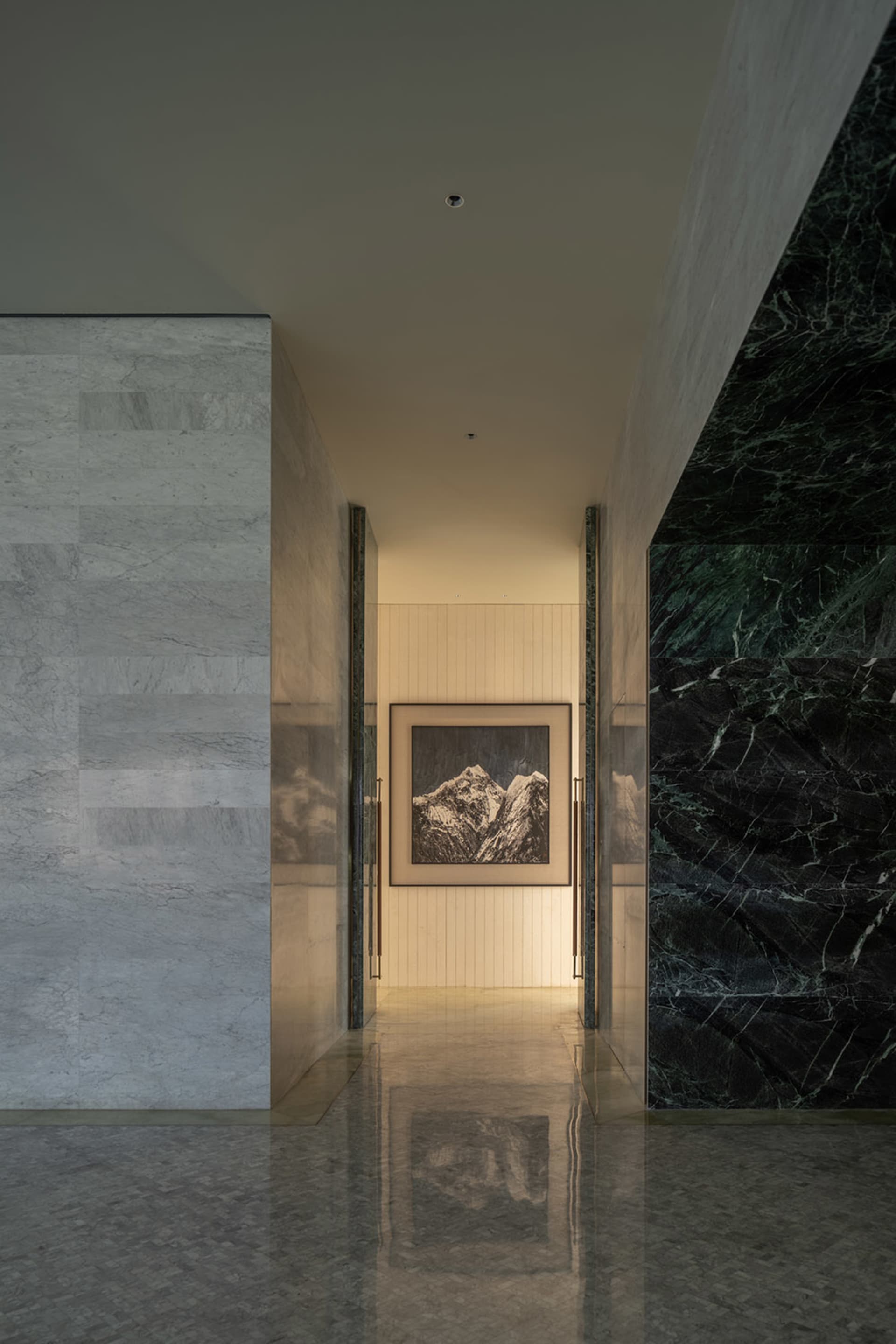 A serene, minimalist corridor featuring black and white marble walls.