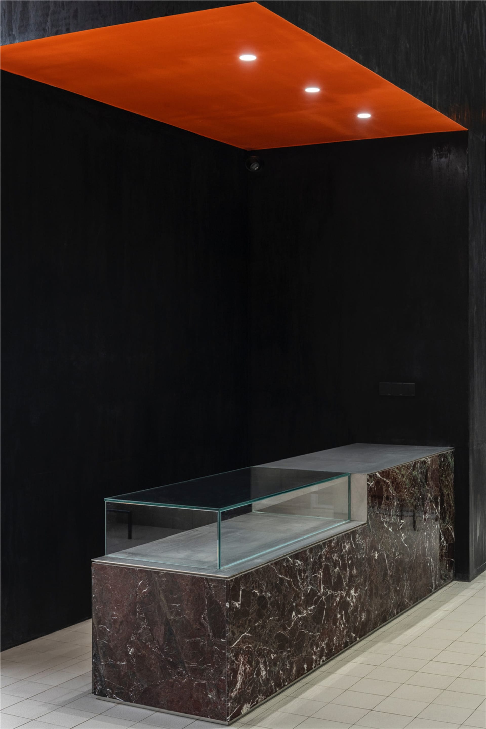Modern interior with a sleek, minimalist coffee shop counter featuring marble and glass.