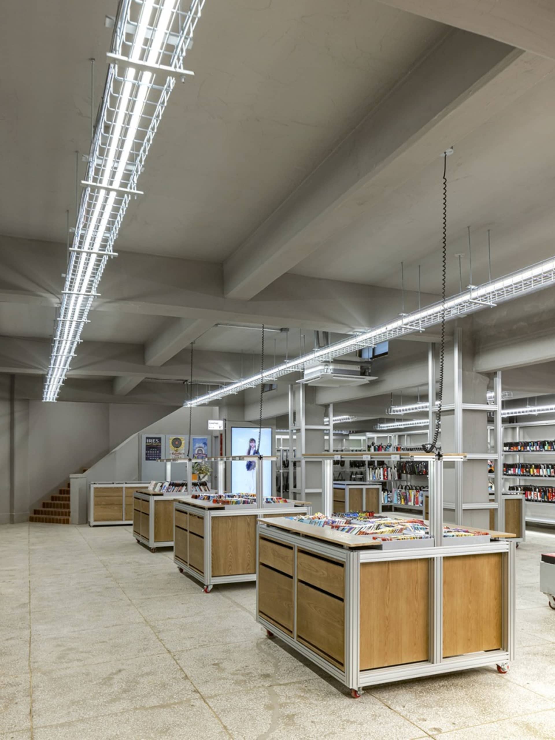 現代工業風零售店，展示木質展示桌與金屬層架單元。