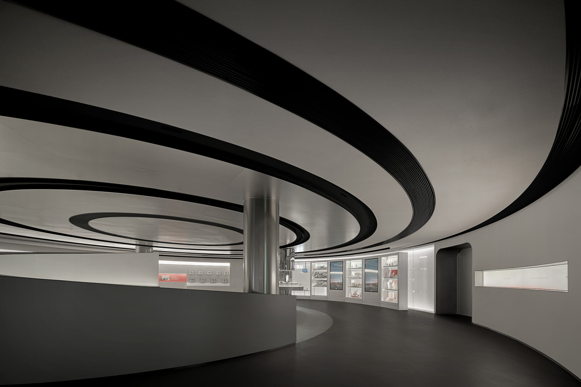 Modern black and white circular interior space with metallic accents