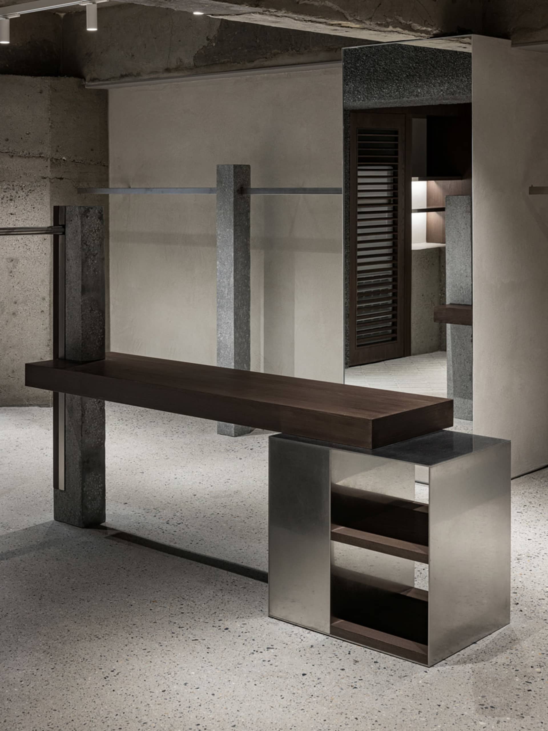 Modern industrial retail storefront featuring concrete, steel, and glass materials.