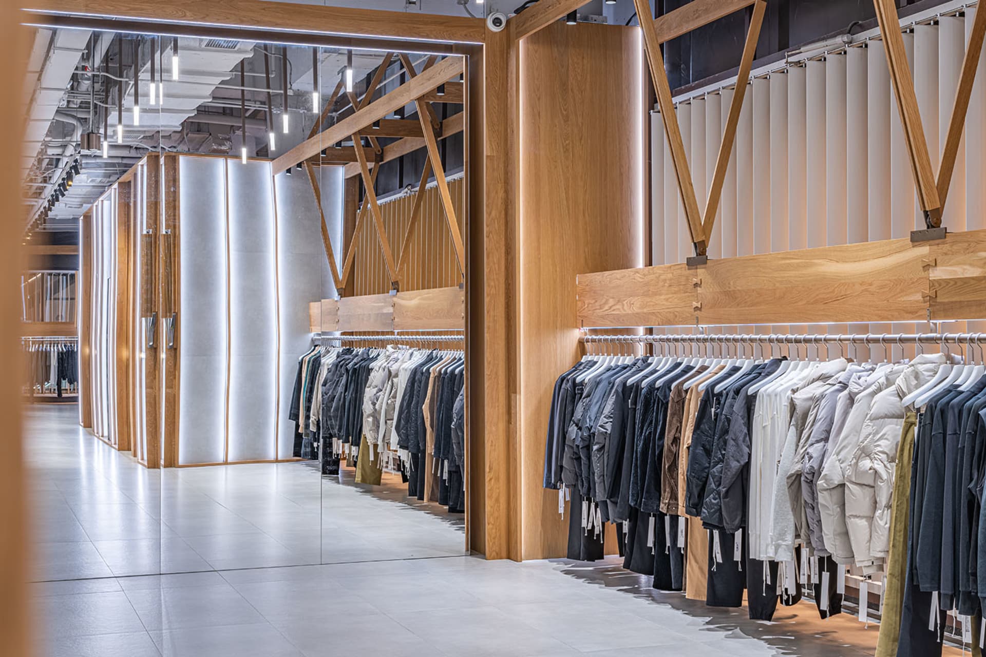 一間以簡約設計為主的現代服飾店，採用木質與混凝土材質。