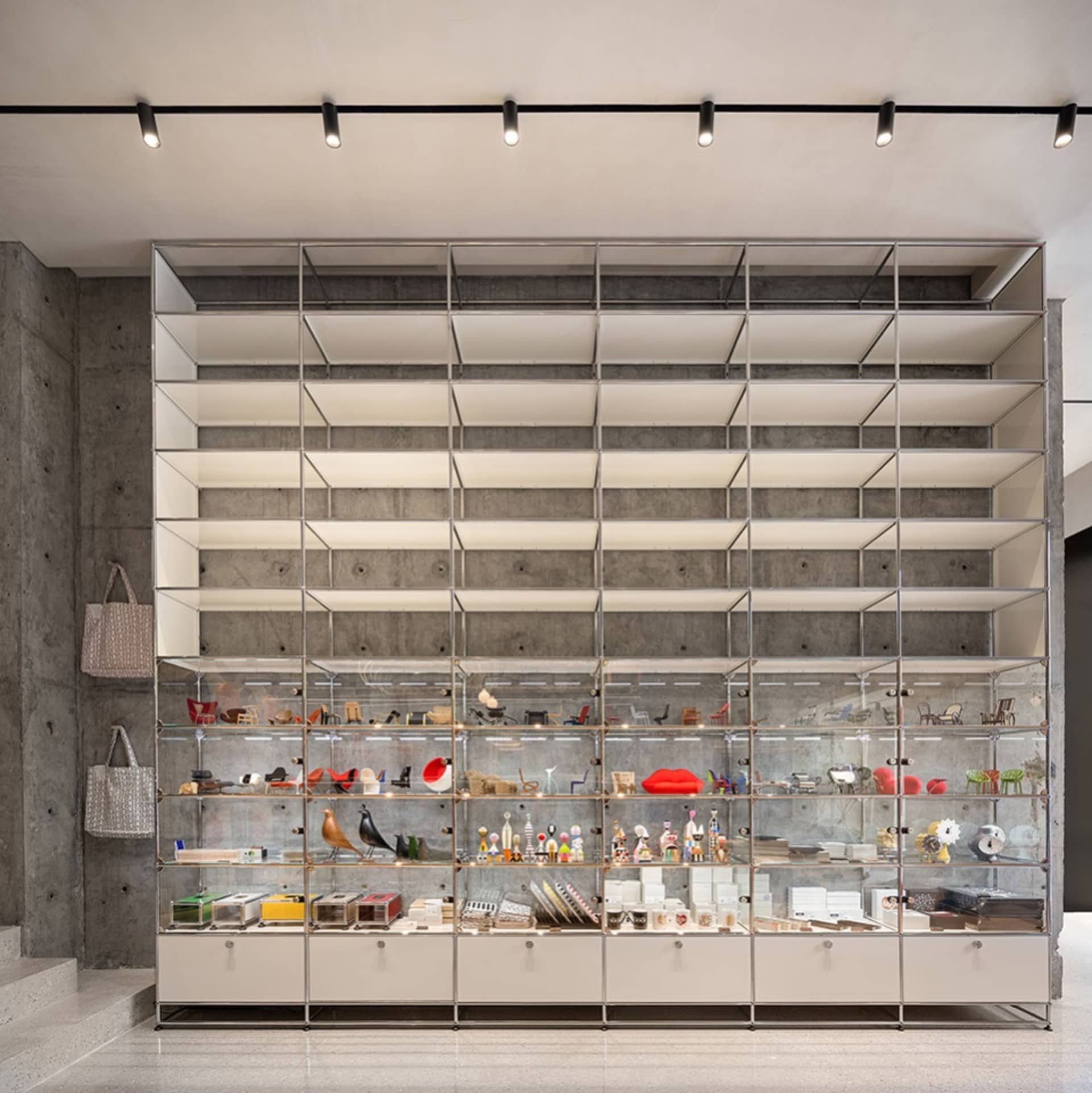 A modern storefront with glass walls and concrete structures.