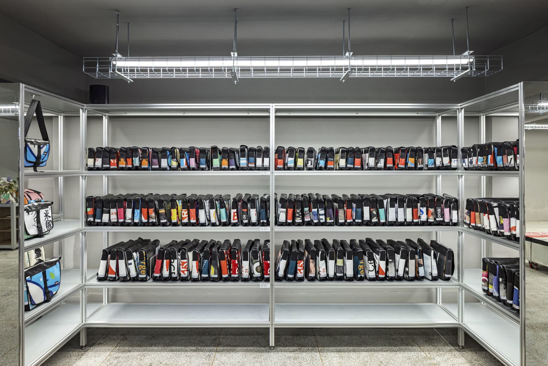 Metal shelving units filled with bags in a row.