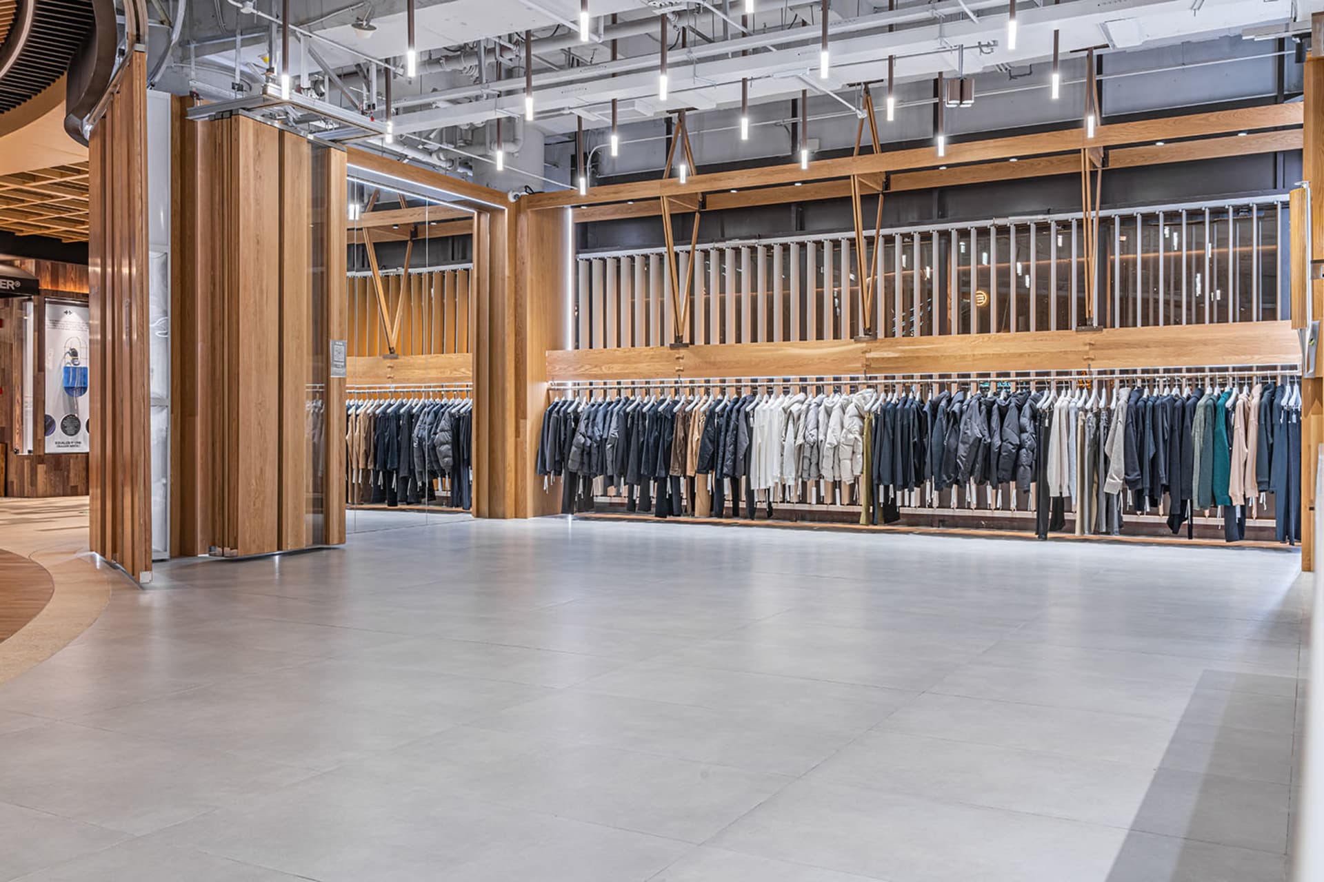 現代服飾零售店,展示木質衣架及陳列其上的服飾商品。