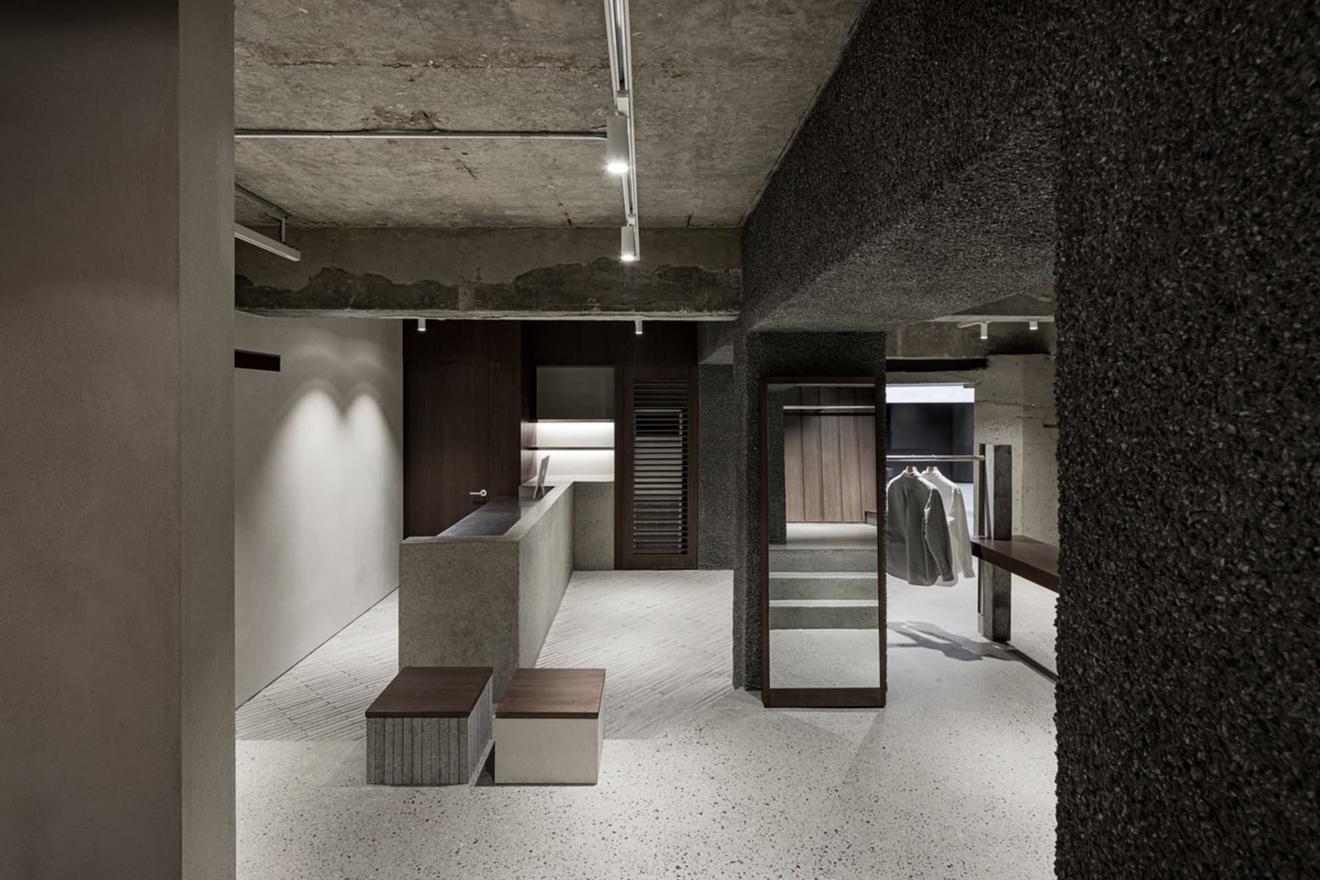 A modern industrial shoe shop with concrete floors, walls, and accents.