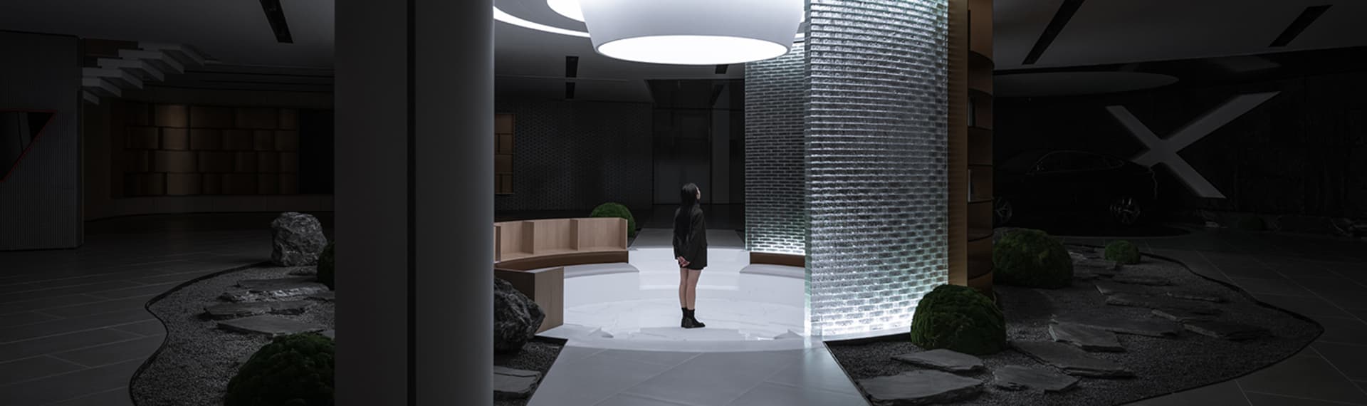 A modern lobby interior with glass walls, metal accents, and concrete flooring.