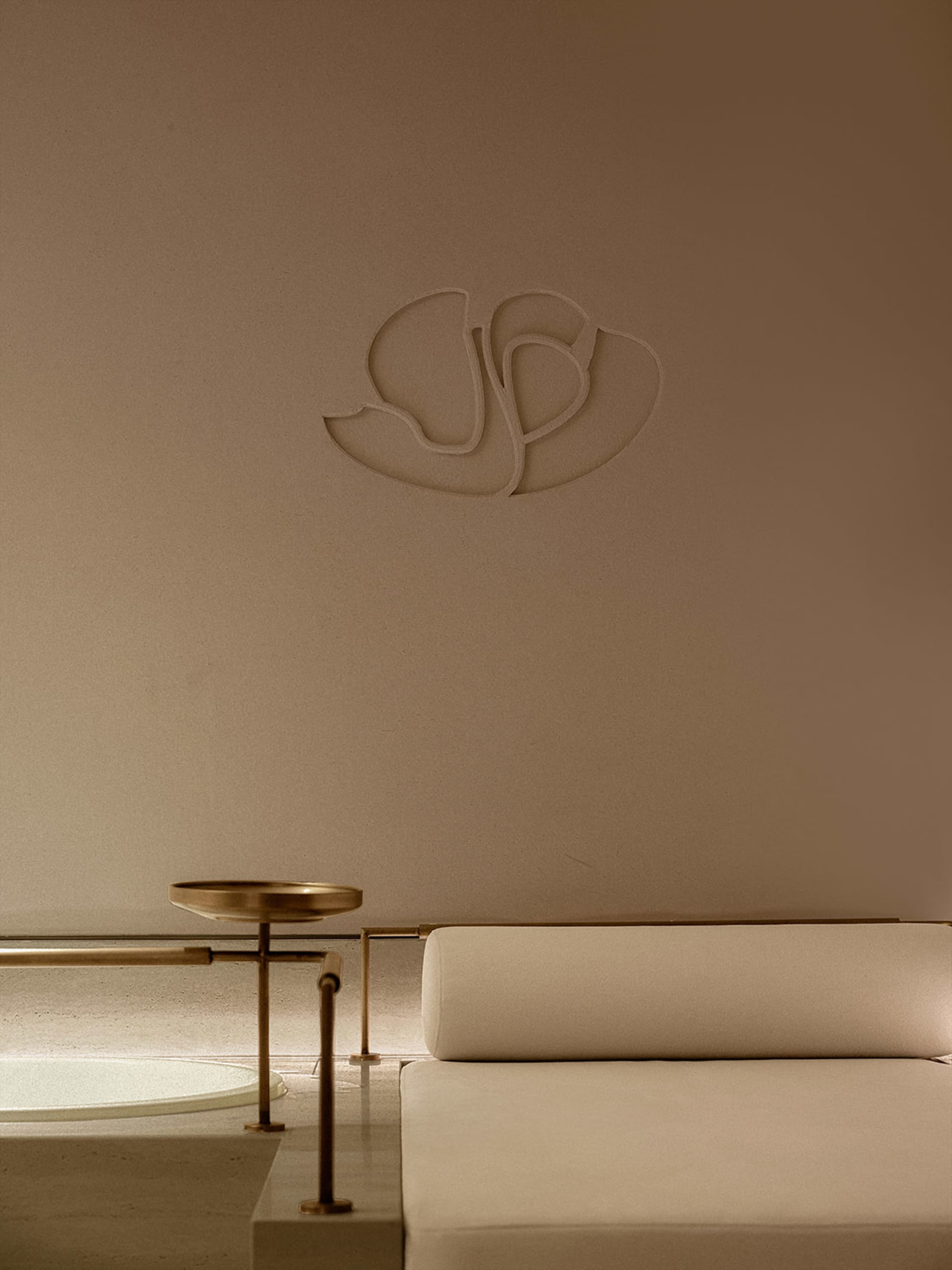 Modern minimalist interior design featuring a metal accent and beige upholstery.