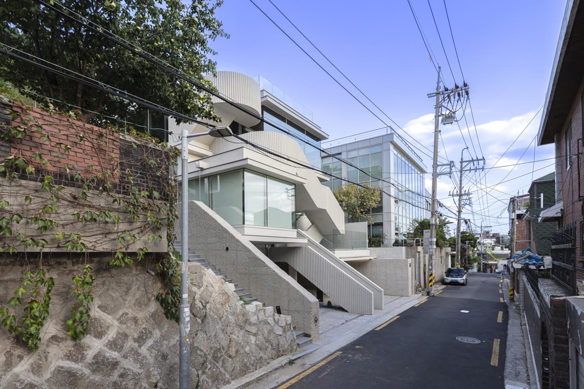 Modern minimalist residential architecture featuring glass walls and concrete stairs.
