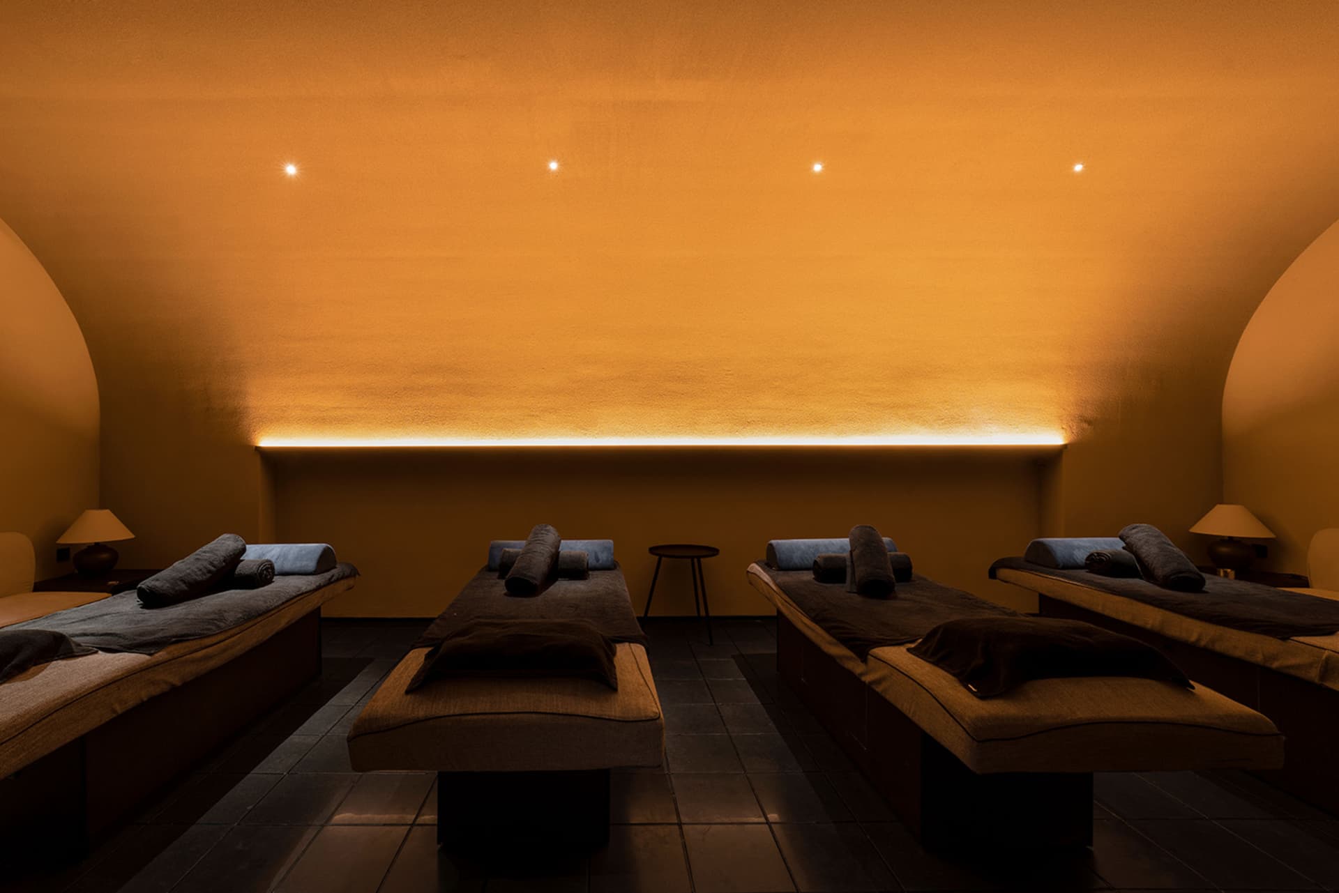 Spa treatment room with fabric cushions and dim lighting