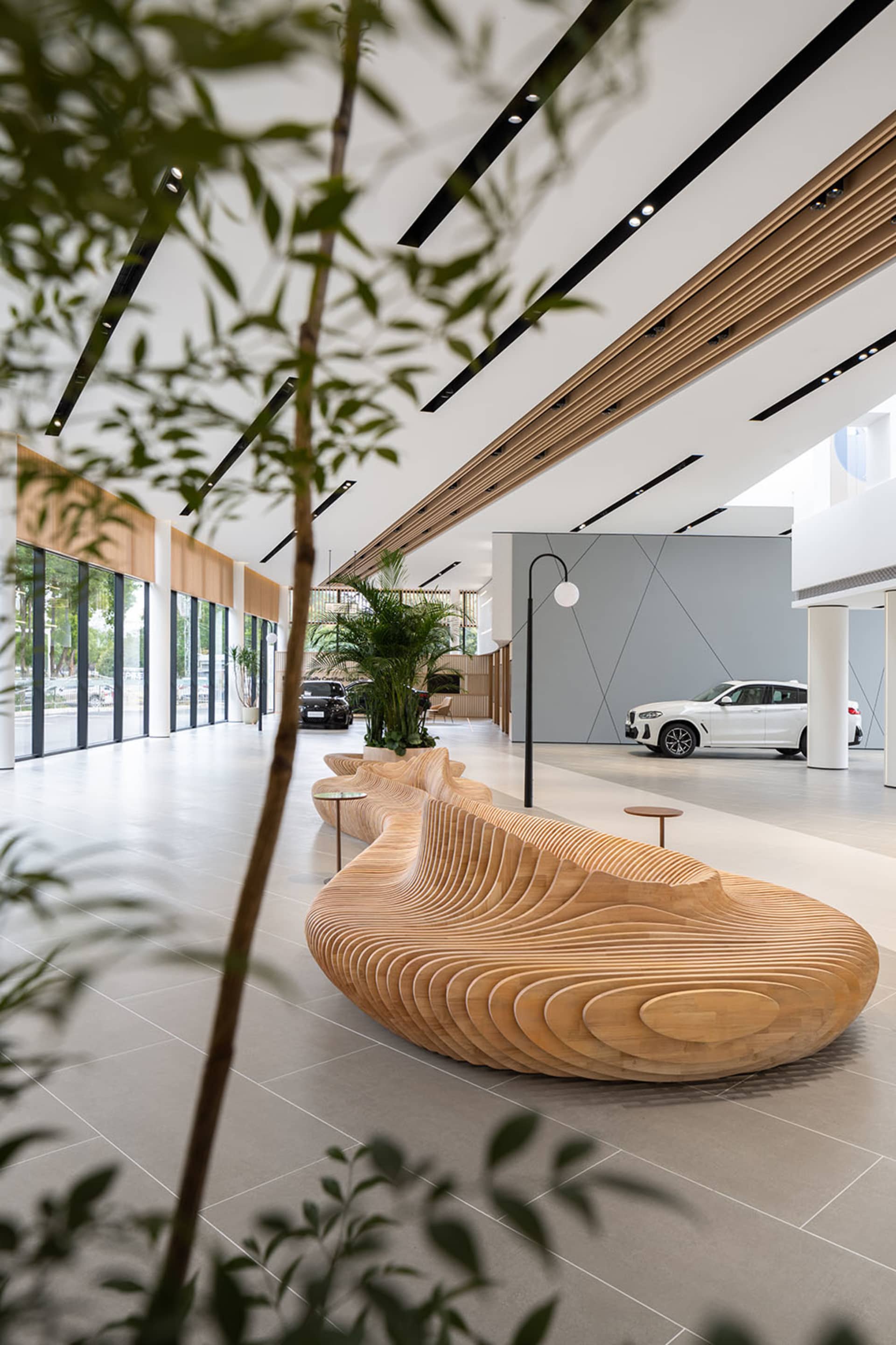 現代汽車展示廳內部，配有木質座椅與大型窗戶。