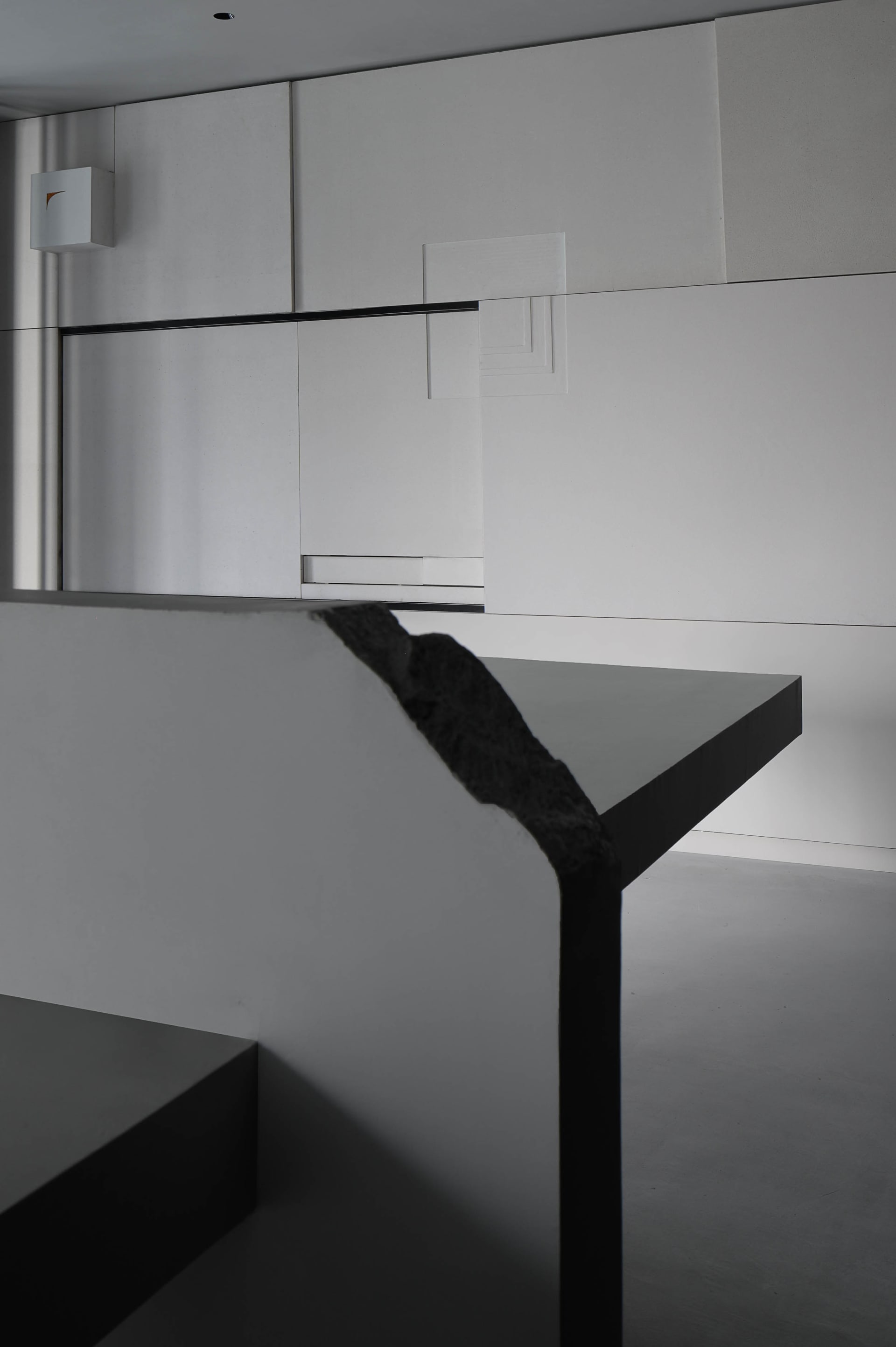 A minimalist bedroom with a concrete floor and walls, featuring a sleek design and modern style.