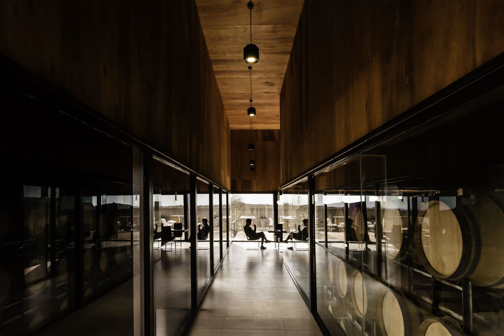 Industrial minimalist wine tasting room with wood, concrete, and glass materials.