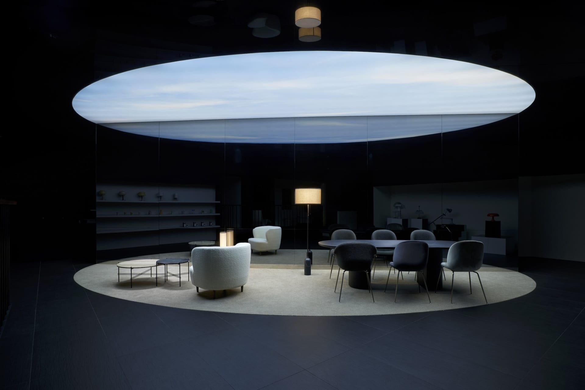 A modern industrial-style office space featuring a metal desk, glass walls, and minimalist design elements.