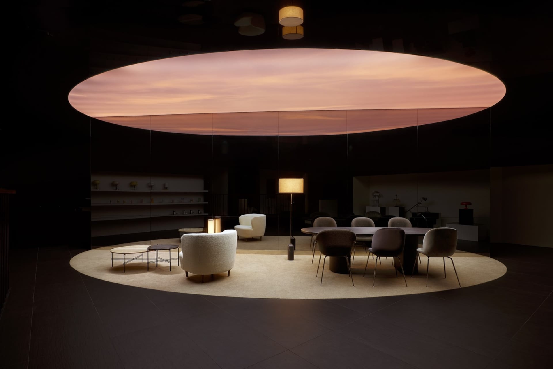 A modern conference room featuring wooden furniture, including a long oval table surrounded by armchairs and a couch.